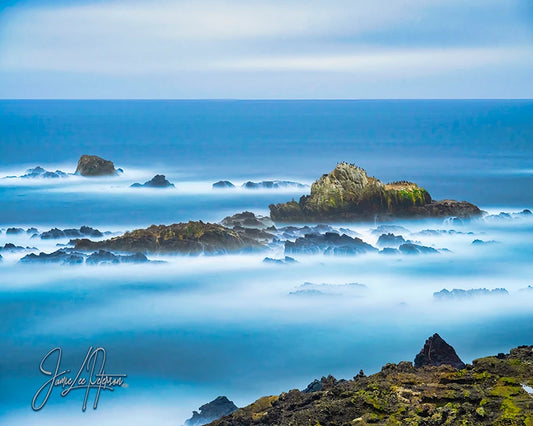 Dreamlike seascape of Point Lobos with misty waters swirling around craggy rocks, a calming presence