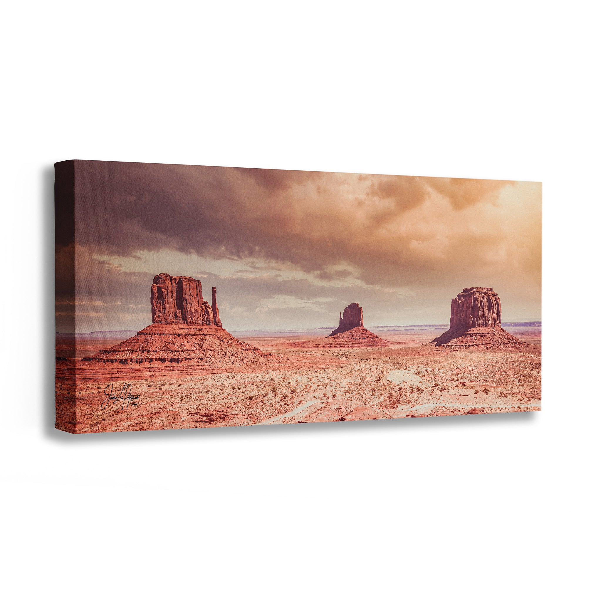 Canvas print of a desert landscape with rock formations and a cloudy sky.