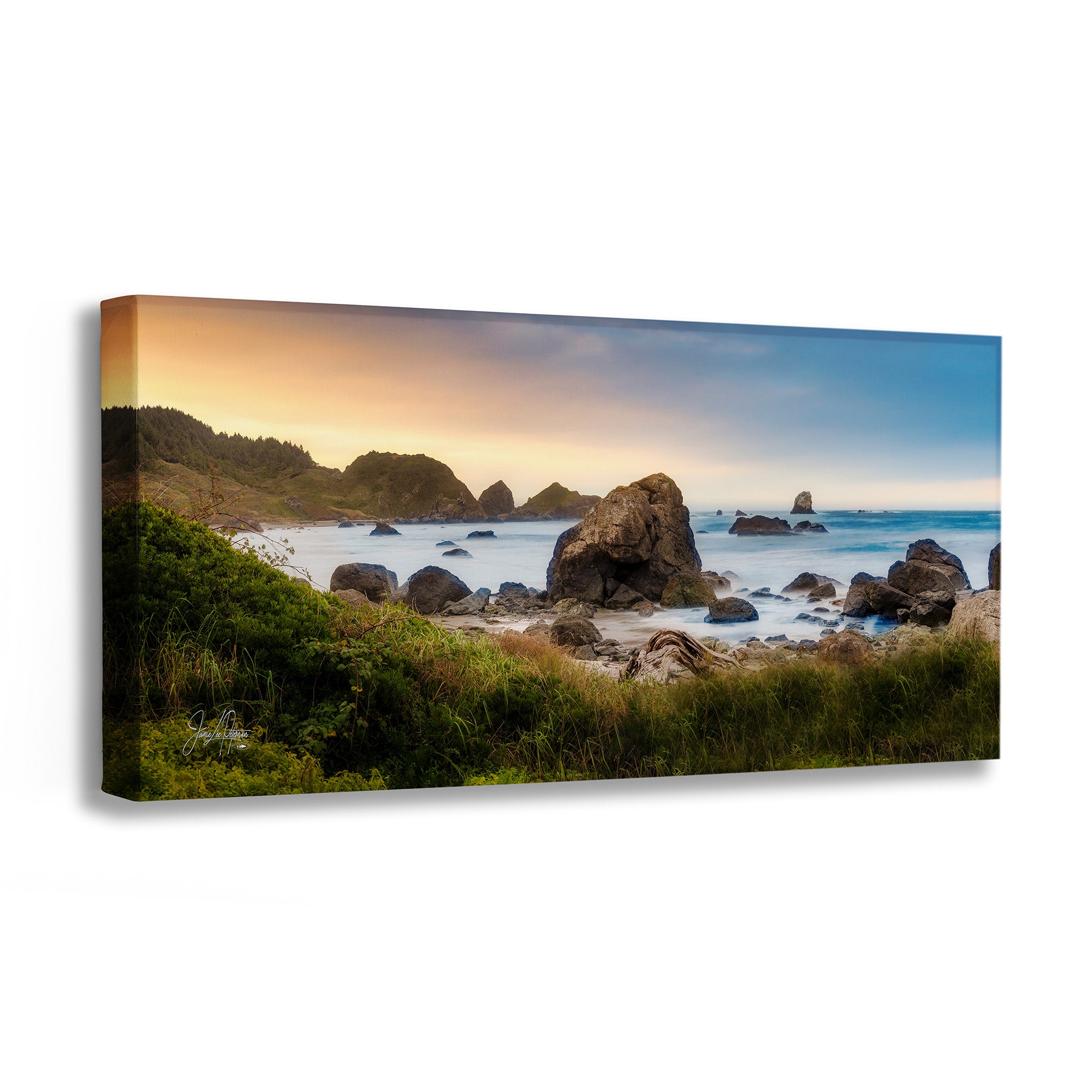 A panoramic canvas wall art print depicting a rocky coastal beach at sunset, shown as a three-dimensional gallery wrap on a white background.