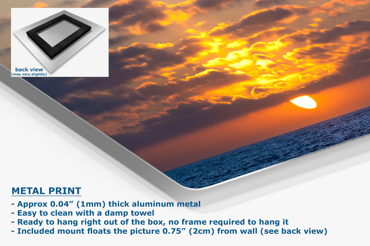 A metal wall art print showing a dramatic sunset over the ocean, displayed at an angle with a small inset back view and product text describing the aluminum finish and mounting details.