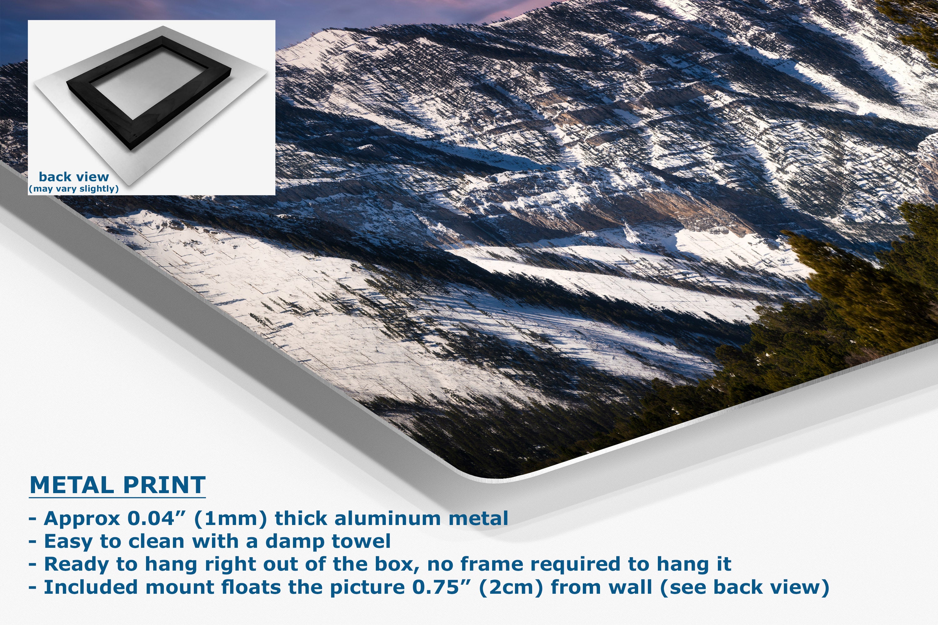 A large wall art print showing a snowy mountain landscape, displayed at an angle with product details and text on a white background. An inset shows the back view of the print with a black frame.