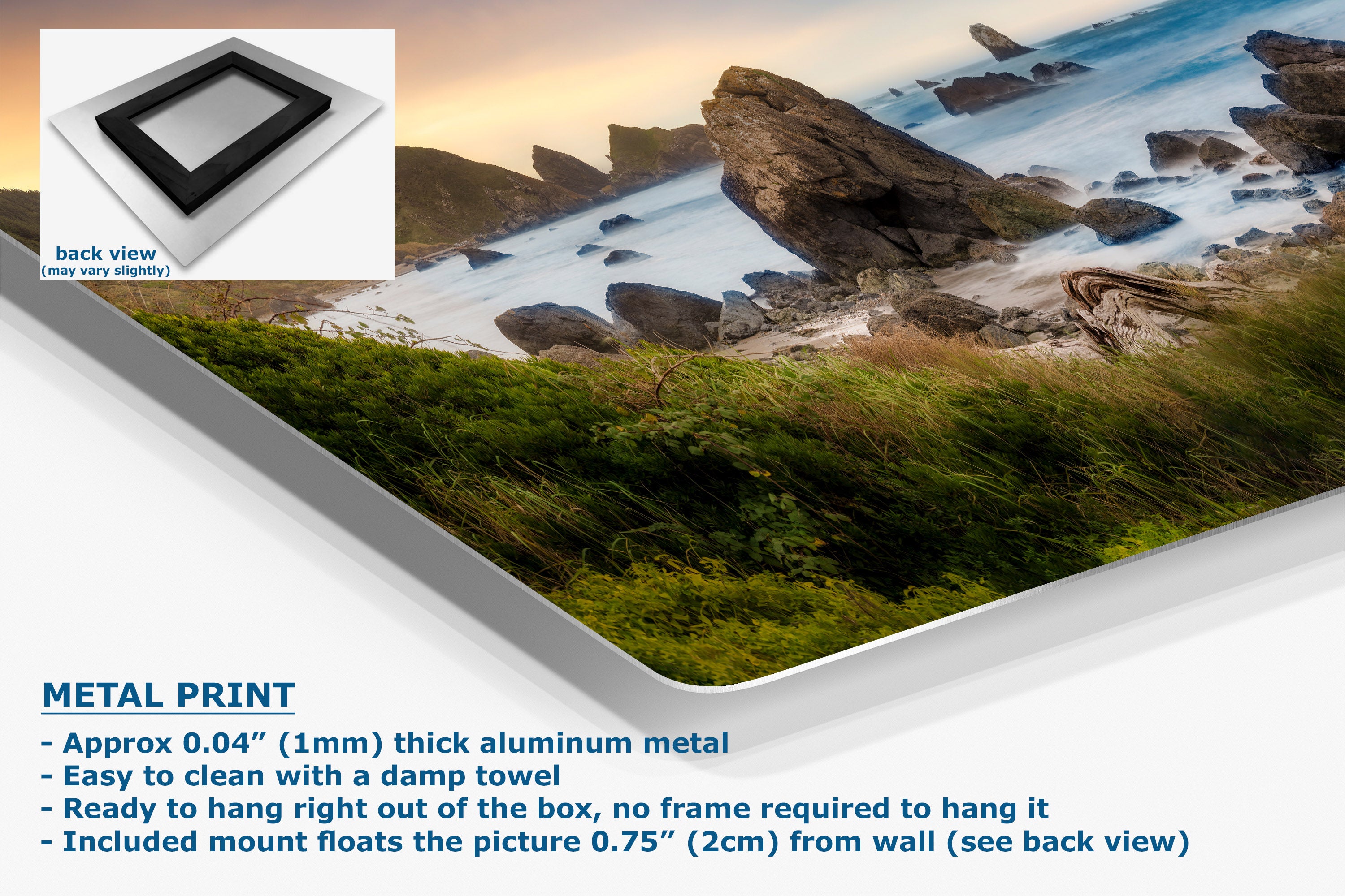 A metal wall art print showing a coastal rocky shoreline with green grass in the foreground and blue water, presented at an angle with a small back-view inset and product text describing the aluminum finish and mounting details.