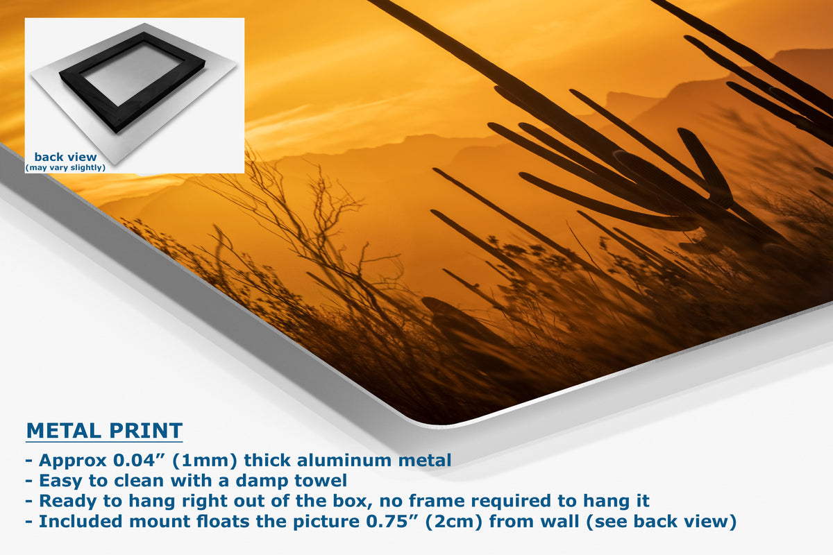 A metal wall art print panel shown at an angle with a desert cactus landscape design in orange, yellow, and brown tones. The image includes a small back-view inset, product text reading 'METAL PRINT,' and a white background.
