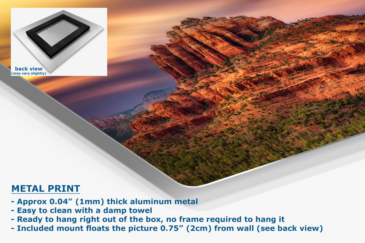 A corner view of a metal print poster of a desert canyon landscape at sunset, angled with product details and text overlays. An inset shows the back view of the print with a black frame mount.