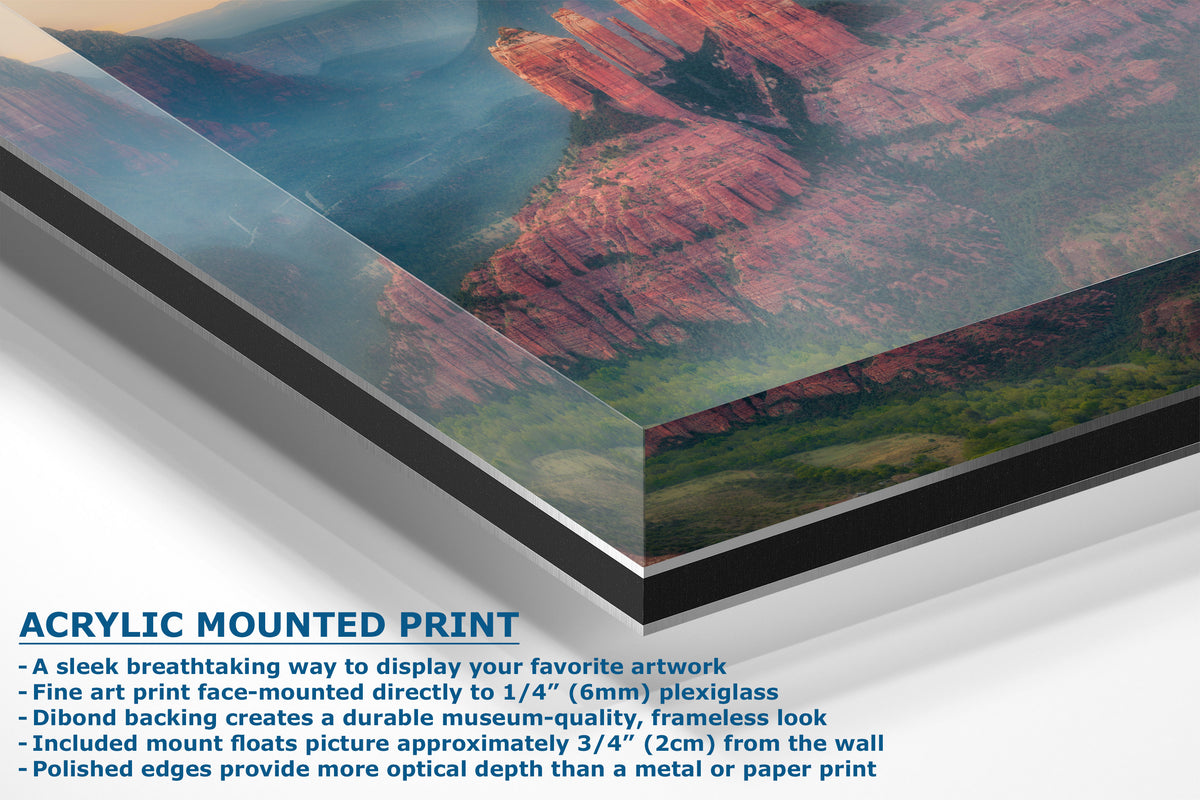 A corner view of an acrylic-mounted art print of a red rock canyon landscape, shown at an angle with descriptive text overlay detailing its features.