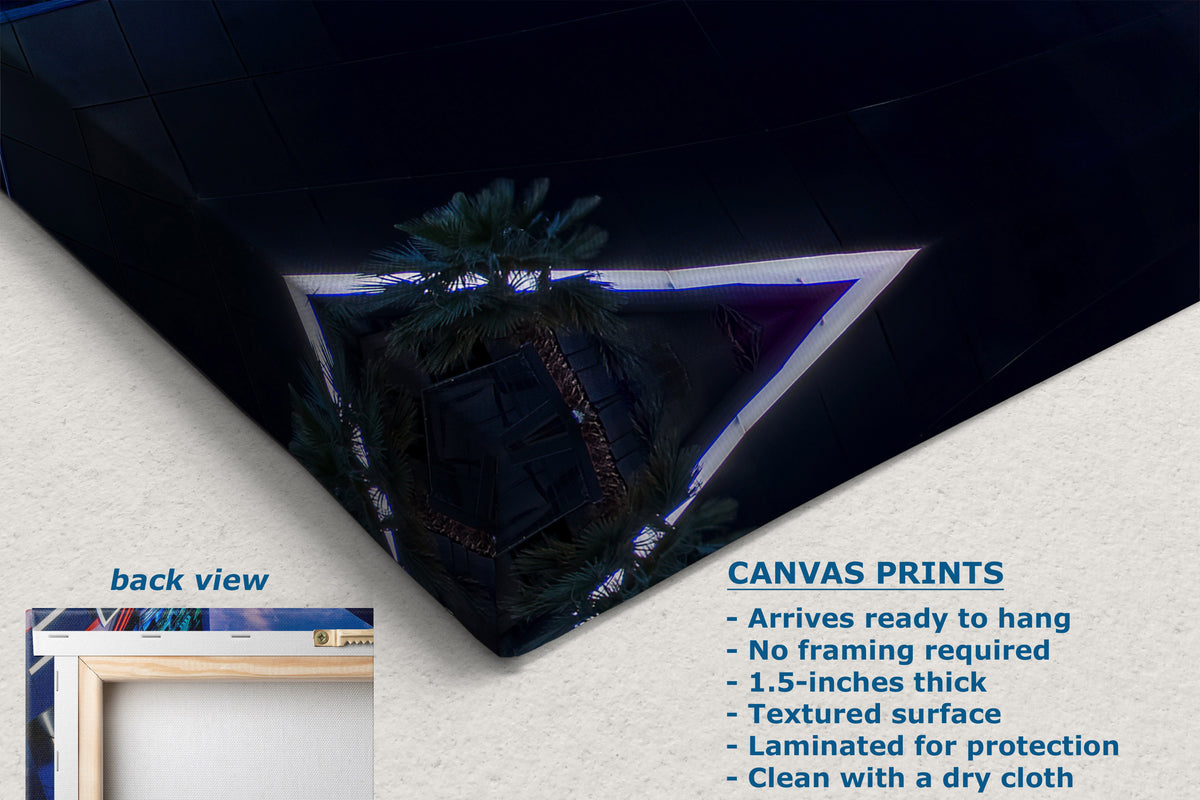 A corner view of a canvas print shown at an angle on a textured white background, with text describing product features and a small inset labeled back view. The artwork depicts a dark architectural scene with palm trees and blue lighting.