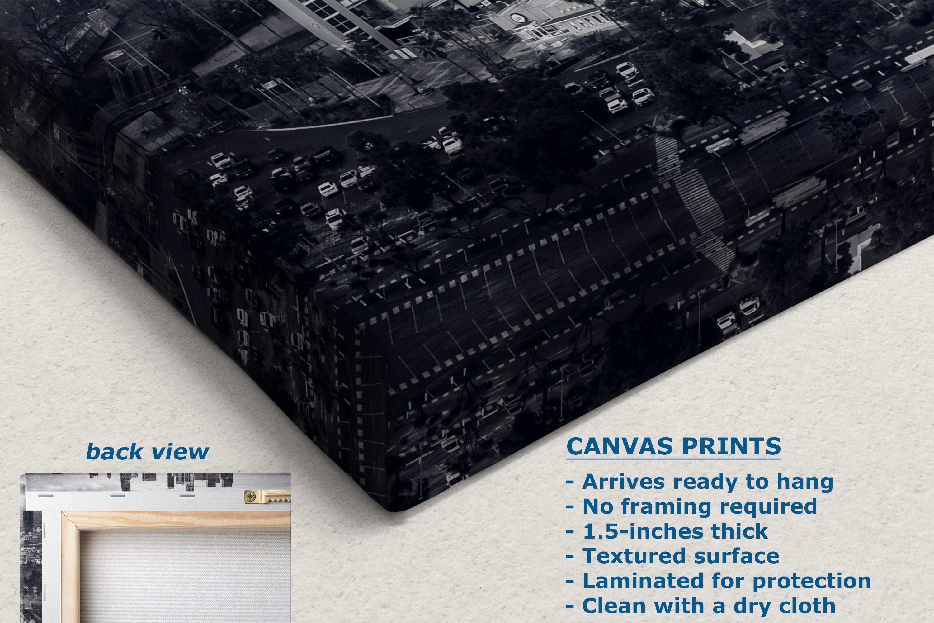 A black and white cityscape canvas print shown at an angle on a light textured background, with a small inset labeled back view and text describing canvas print features.