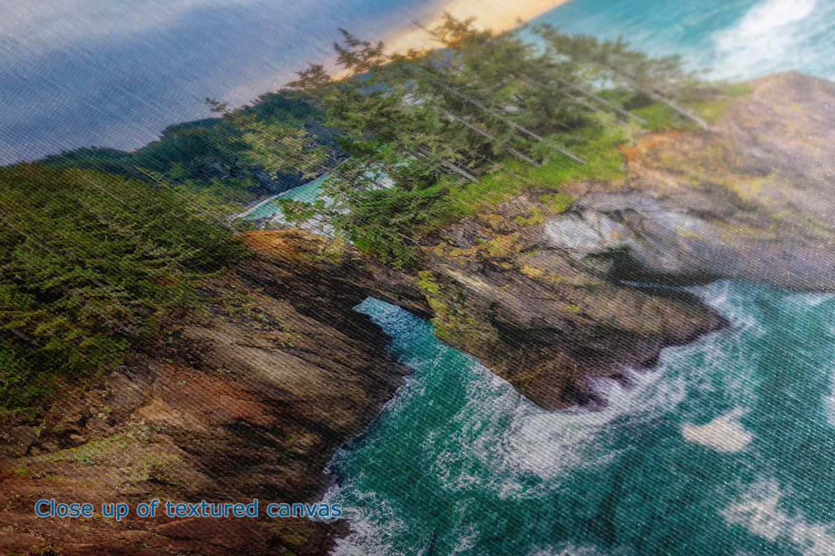 Close-up of the texture of a canvas print depicting a coastal landscape with rocky cliffs, green trees, and turquoise ocean water. Blue text in the lower-left corner reads 'Close up of textured canvas'.