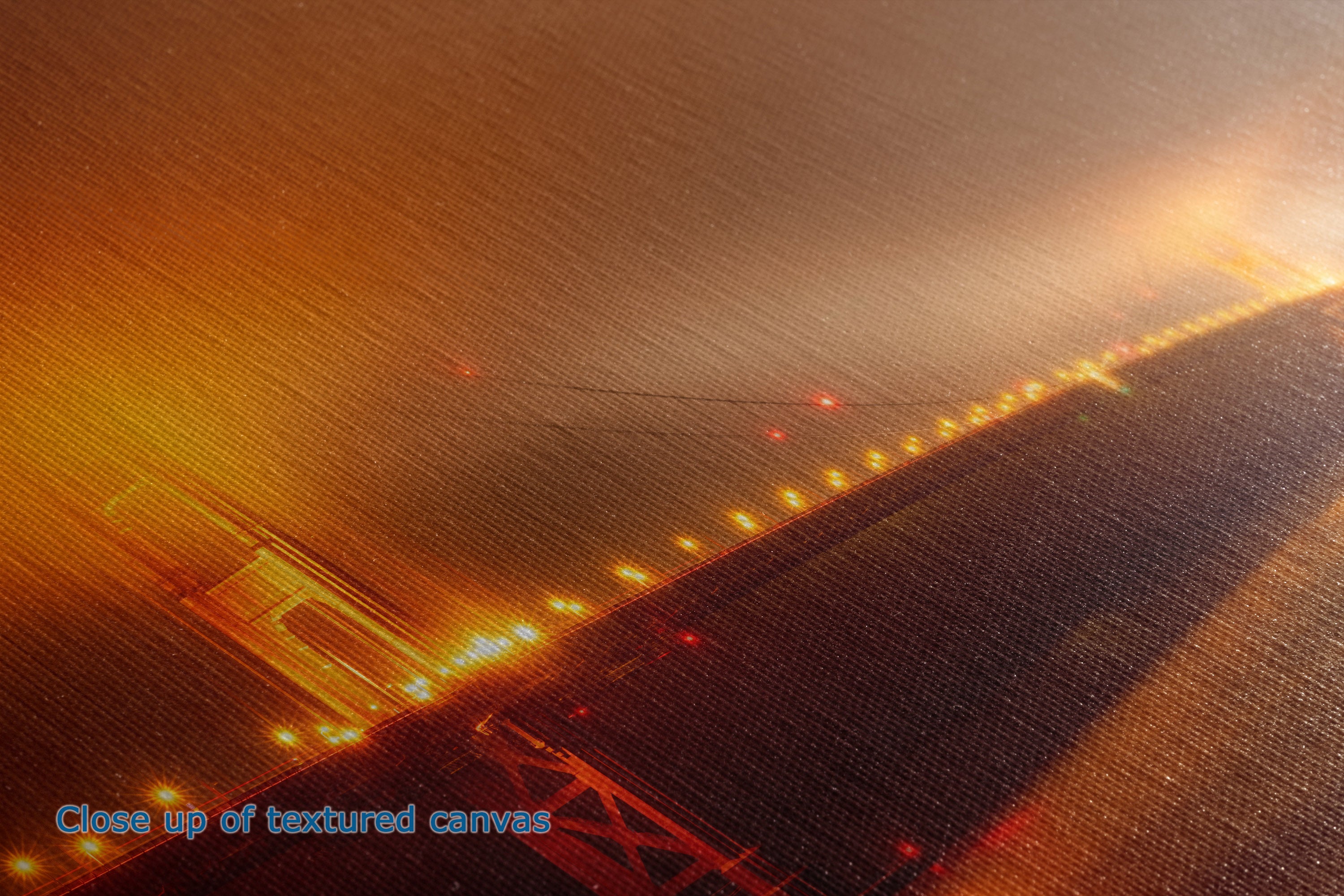 A textured canvas print depicting a dramatic, atmospheric night scene of a bridge illuminated by warm golden and orange lights against a dark, misty sky.