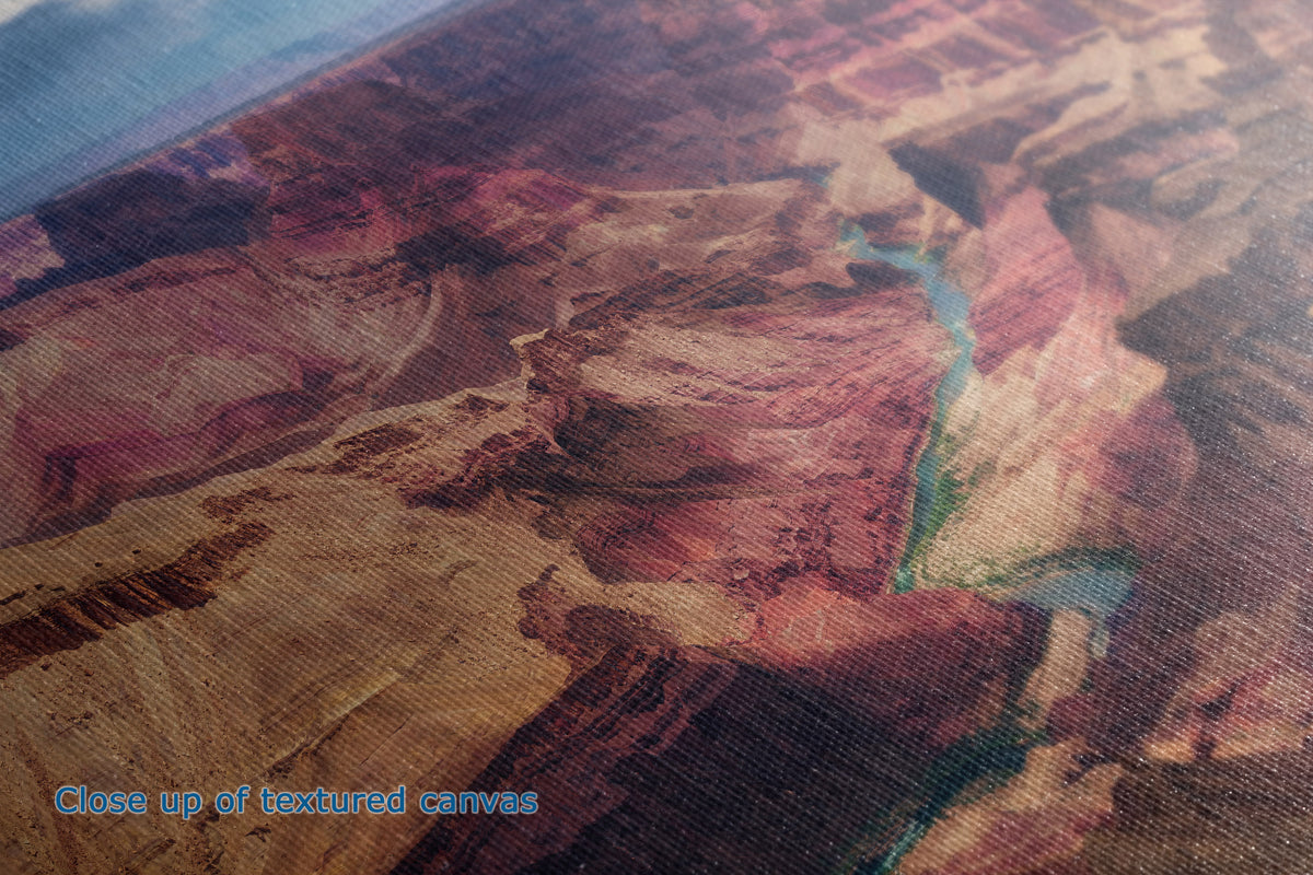 Close-up of a textured canvas print depicting an aerial view of a canyon landscape with a winding river, showing layered red, brown, and tan rock formations.