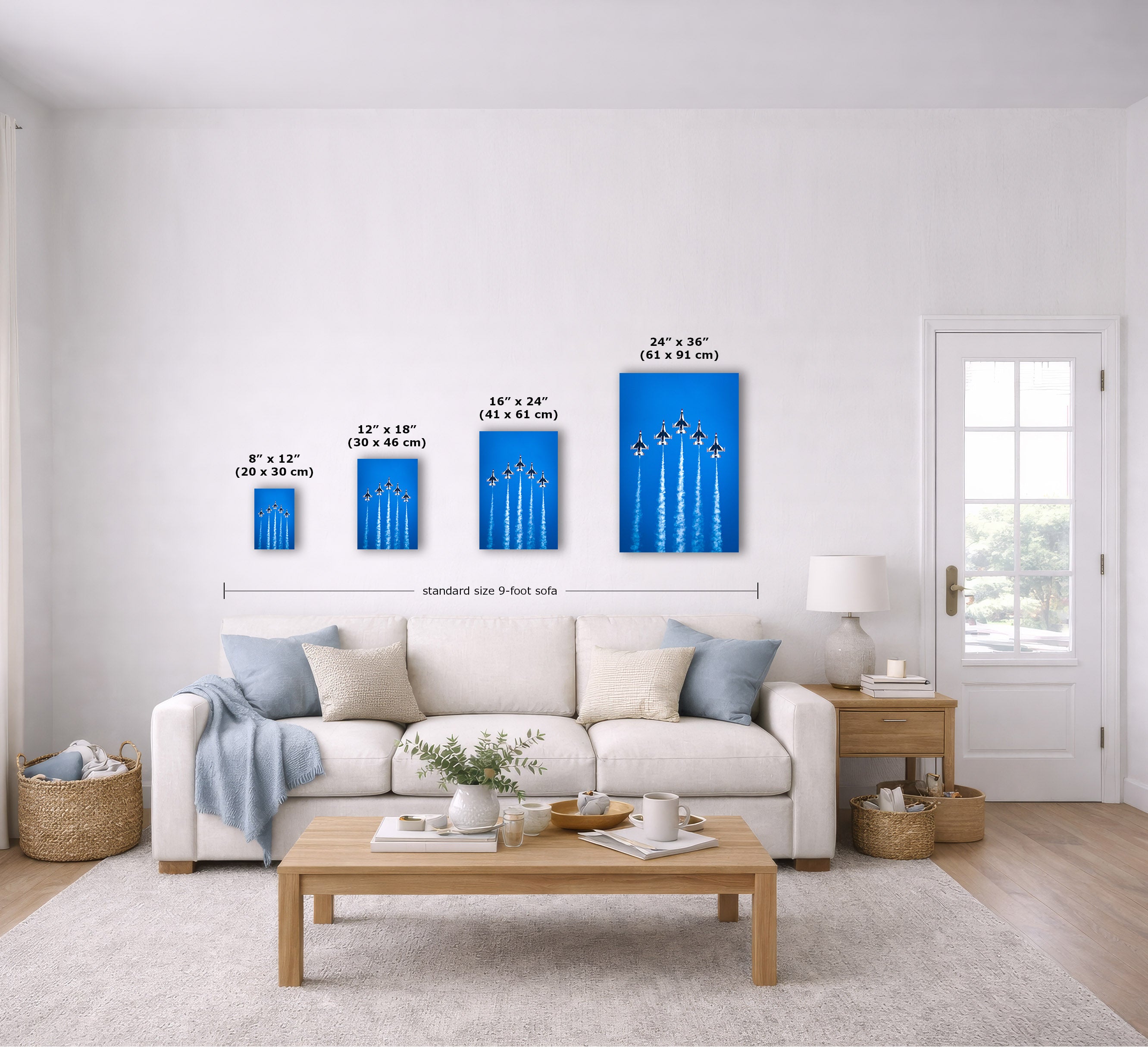 A staged living room shows a set of four vertical blue wall art prints with white line illustrations, each labeled with dimensions. The prints are displayed above a white sofa, with measurement arrows and text indicating sizes from 8"x12" to 24"x36".