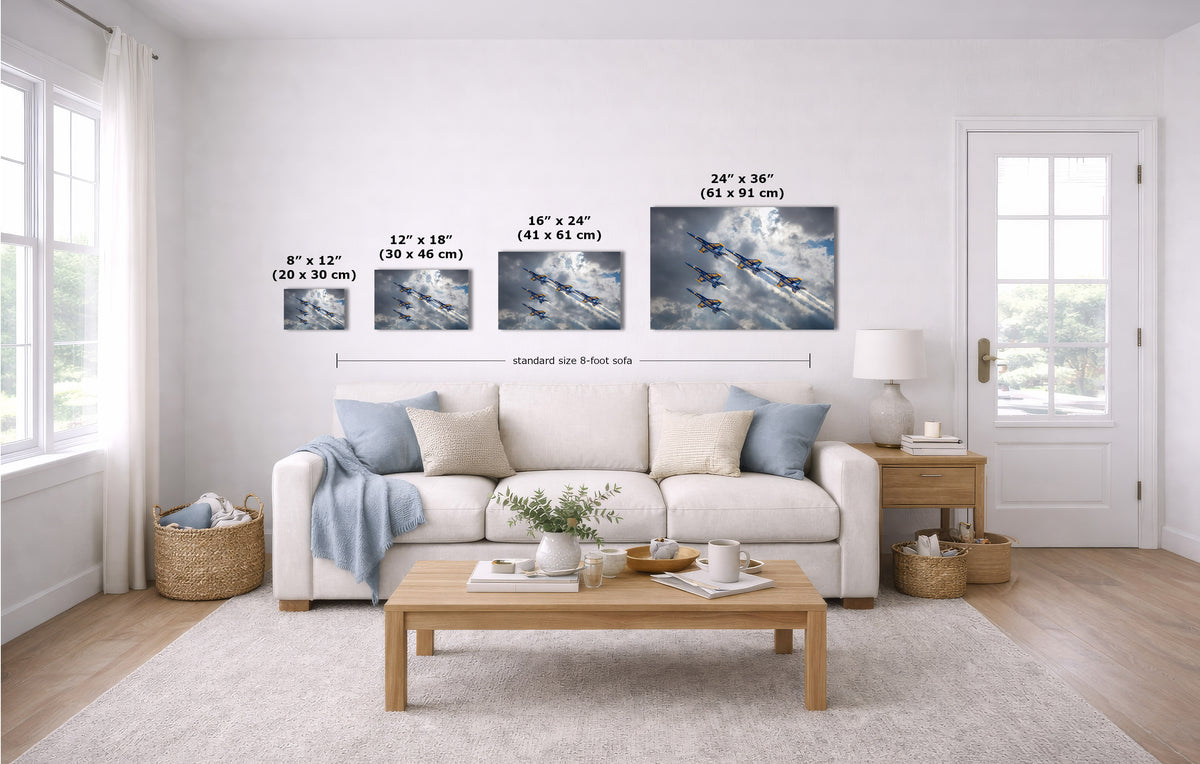 A staged living room with a white sofa, coffee table, and wall-mounted art. The wall art set includes four prints with overlaid size labels: 8 x 12, 12 x 18, 16 x 24, and 24 x 36 inches.