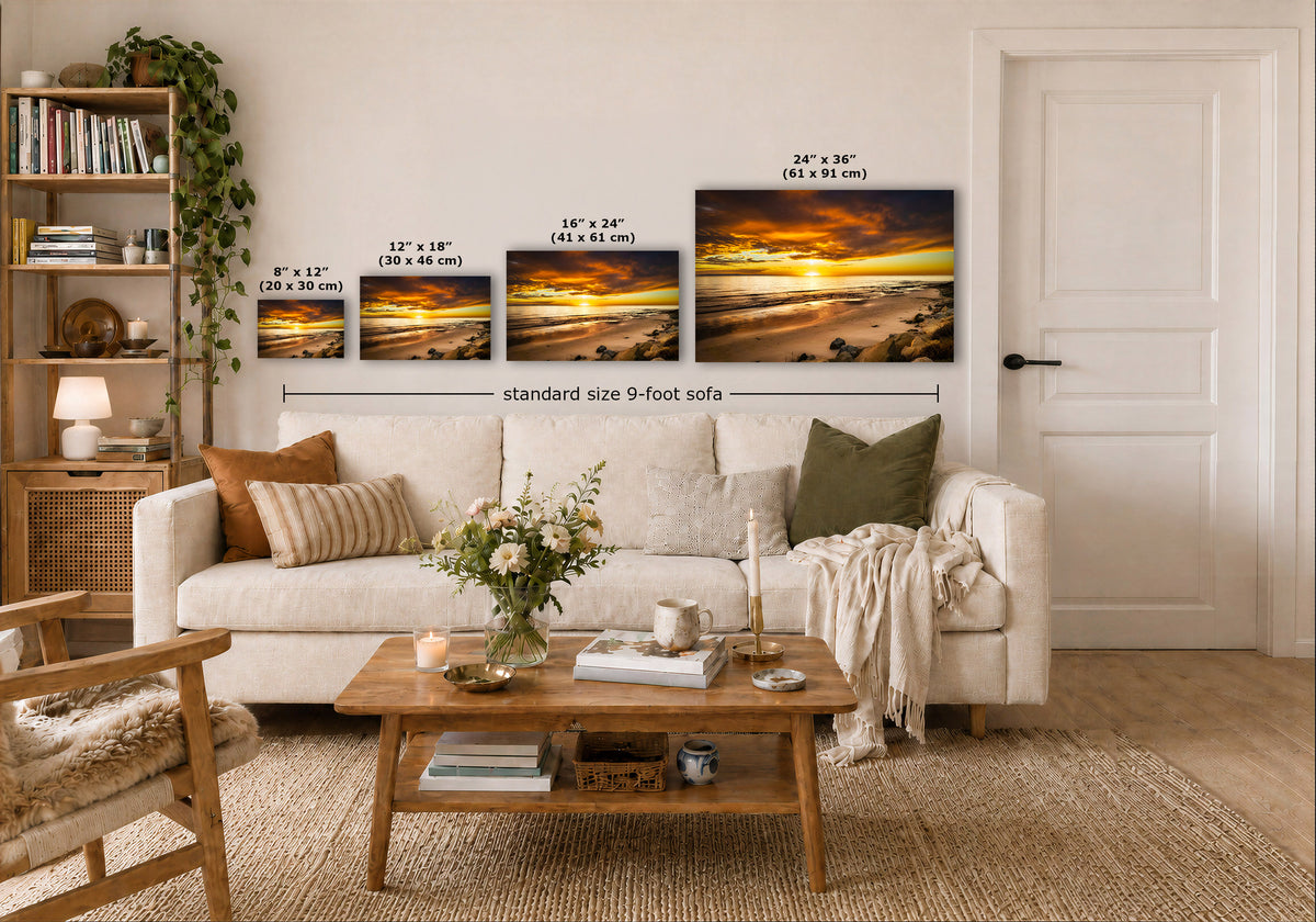 A staged living room shows a white sofa, wooden coffee table, shelving, and a large wall display of four sunset landscape prints with overlaid size labels and a dimension line reading standard size 9-foot sofa.