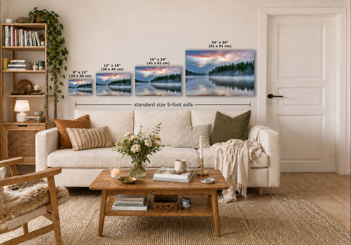 A staged living room shows a white sofa with pillows, a wooden coffee table, shelving, and a door, with three landscape prints mounted above the sofa. The prints depict misty forest lakes, and overlaid text indicates sizes: 8 x 12, 12 x 18, 16 x 24, and 24 x 36, plus a dimension line reading standard size 9-foot sofa.