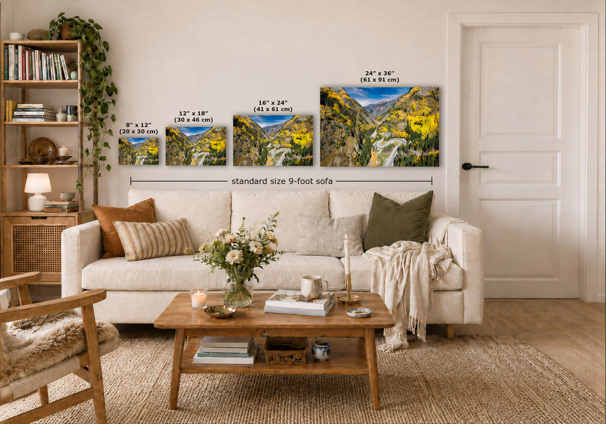 A styled living room showing four landscape art prints above a white sofa, with dimension labels indicating 8 x 12, 12 x 18, and 16 x 24, and 24 x 36 sizes. The prints depict bright yellow aspen trees and mountains.