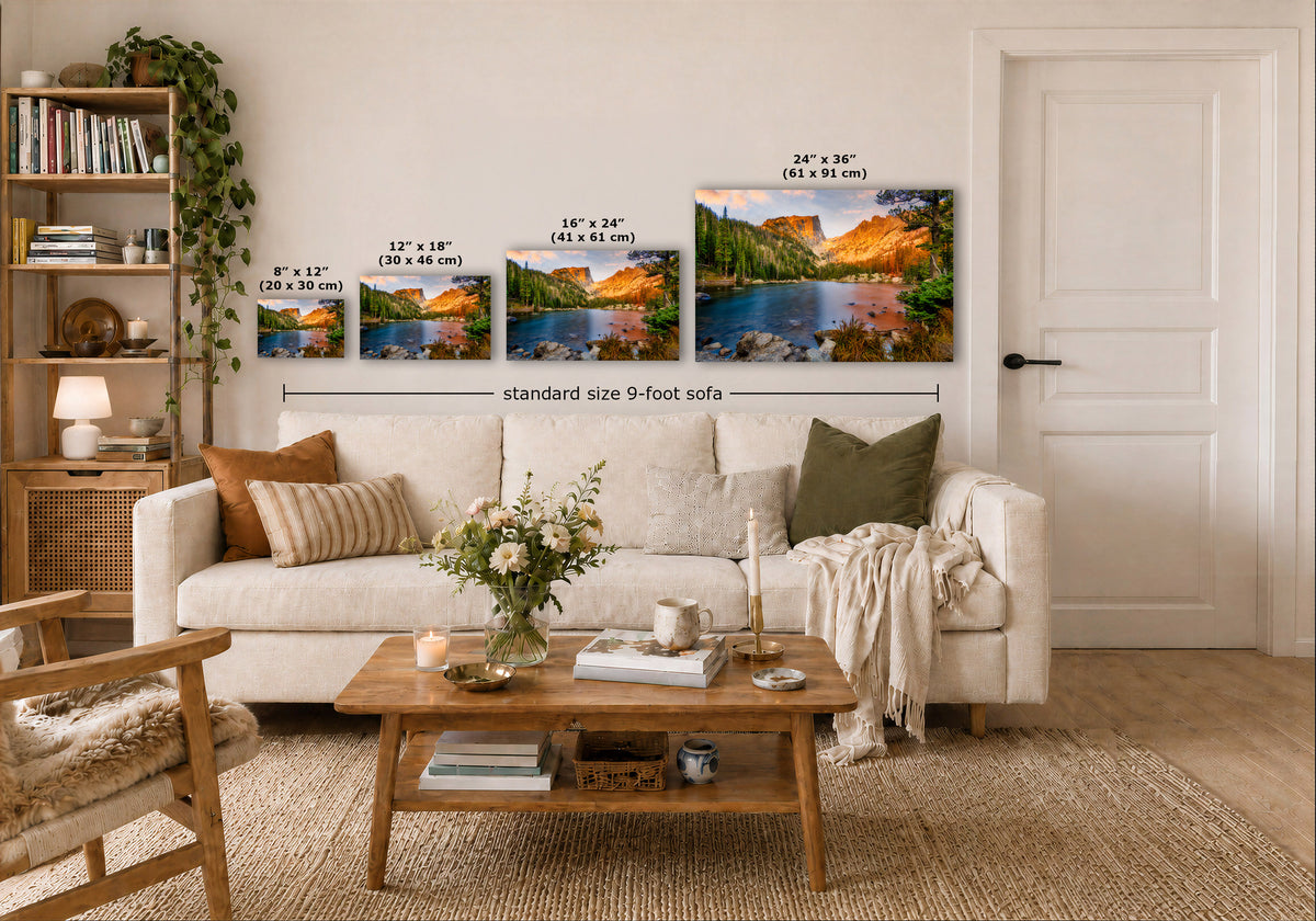 A styled living room showing four landscape art prints above a white sofa, with overlaid size labels for the prints and a dimension line reading standard size 9-foot sofa.