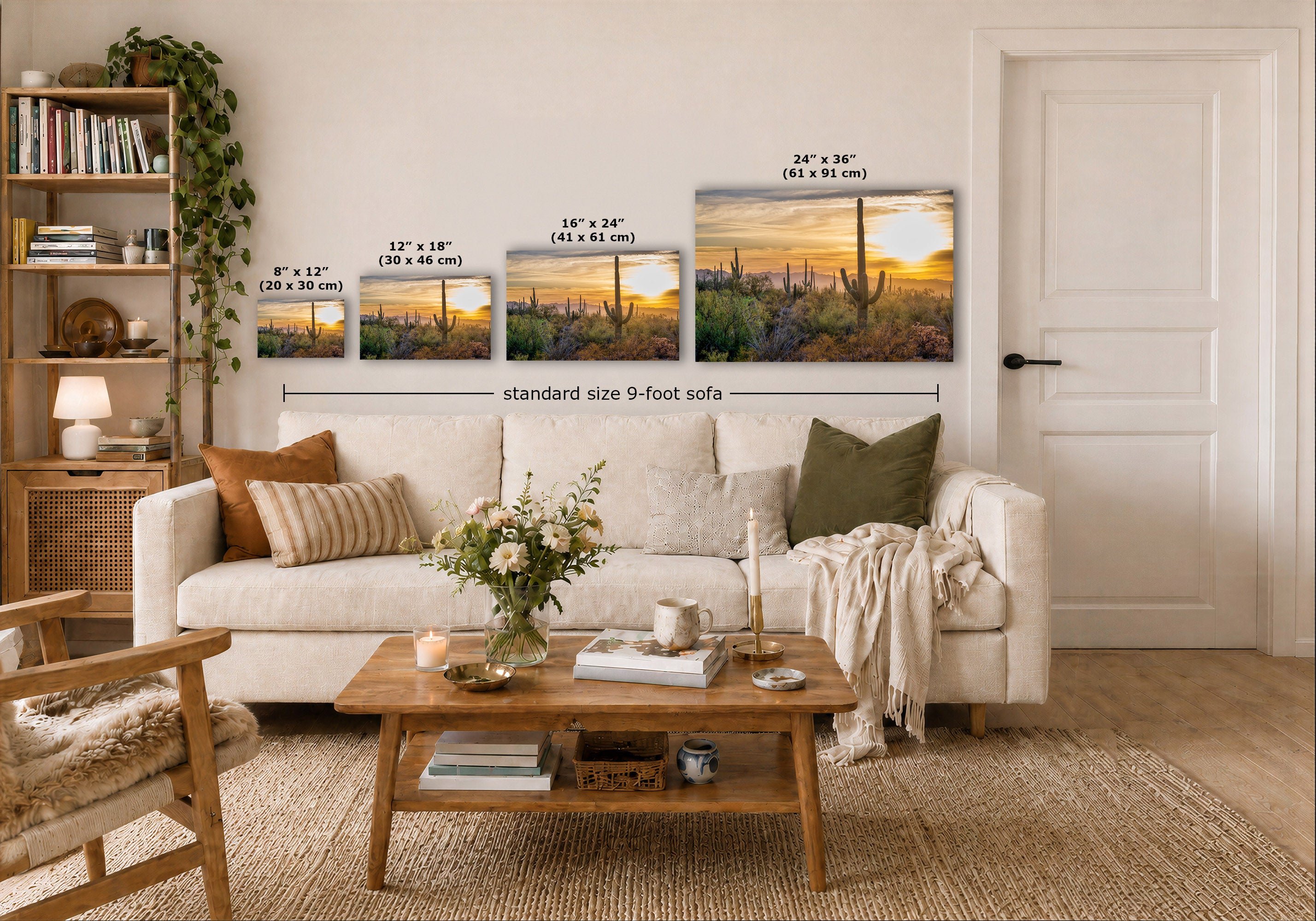 Three desert landscape prints with cactus and sunset scenes displayed on a white wall above a sofa in a styled living room. The prints show size labels in inches and centimeters, with a dimension line reading standard size 9-foot sofa.