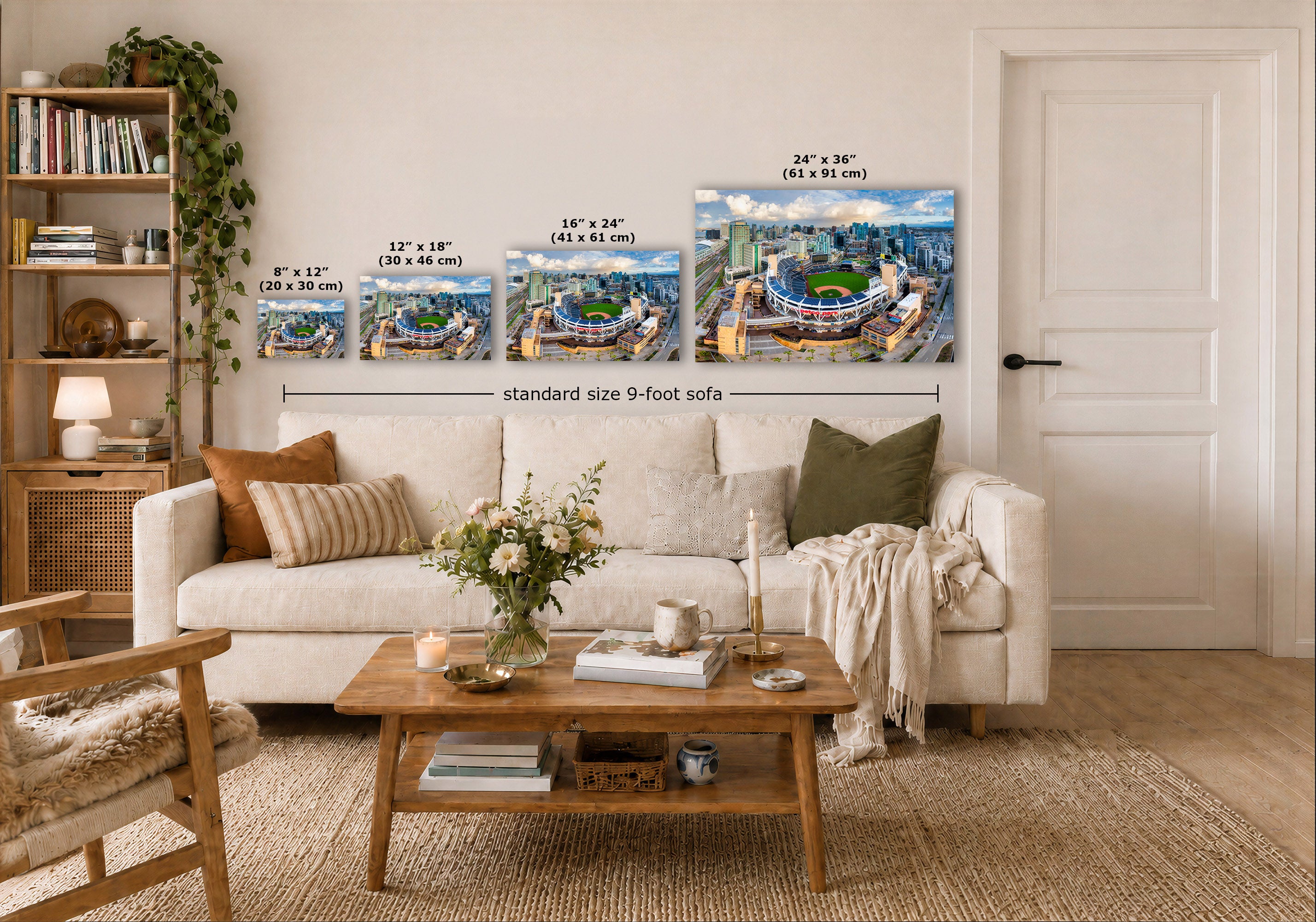 Four wall art prints showing stadium scenes are displayed above a white sofa in a styled living room. White dimension labels and text indicate sizes: 8" x 12" (20 x 30 cm), 12" x 18" (30 x 46 cm), 16" x 24" (41 x 61 cm), and 24" x 36" (61 x 91 cm), with a note reading standard size 9-foot sofa.