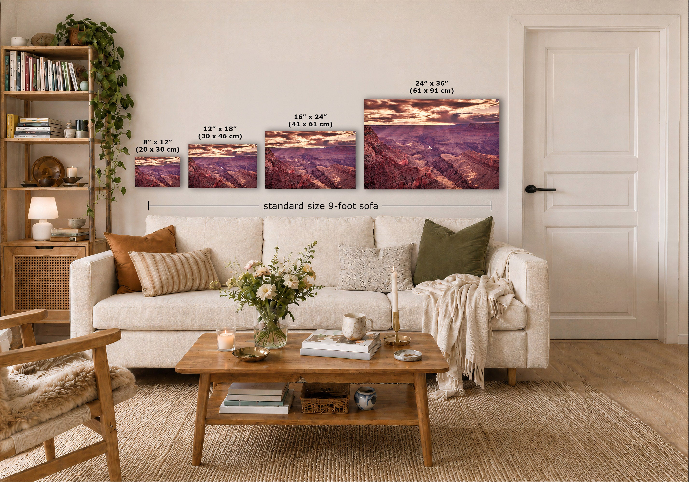 A staged living room shows a white sofa, wooden coffee table, shelving, and a large wall art print above the couch. The wall art depicts a dramatic purple and pink canyon landscape with overlaid size labels for different print sizes and a note reading 'standard size 9-foot sofa'.