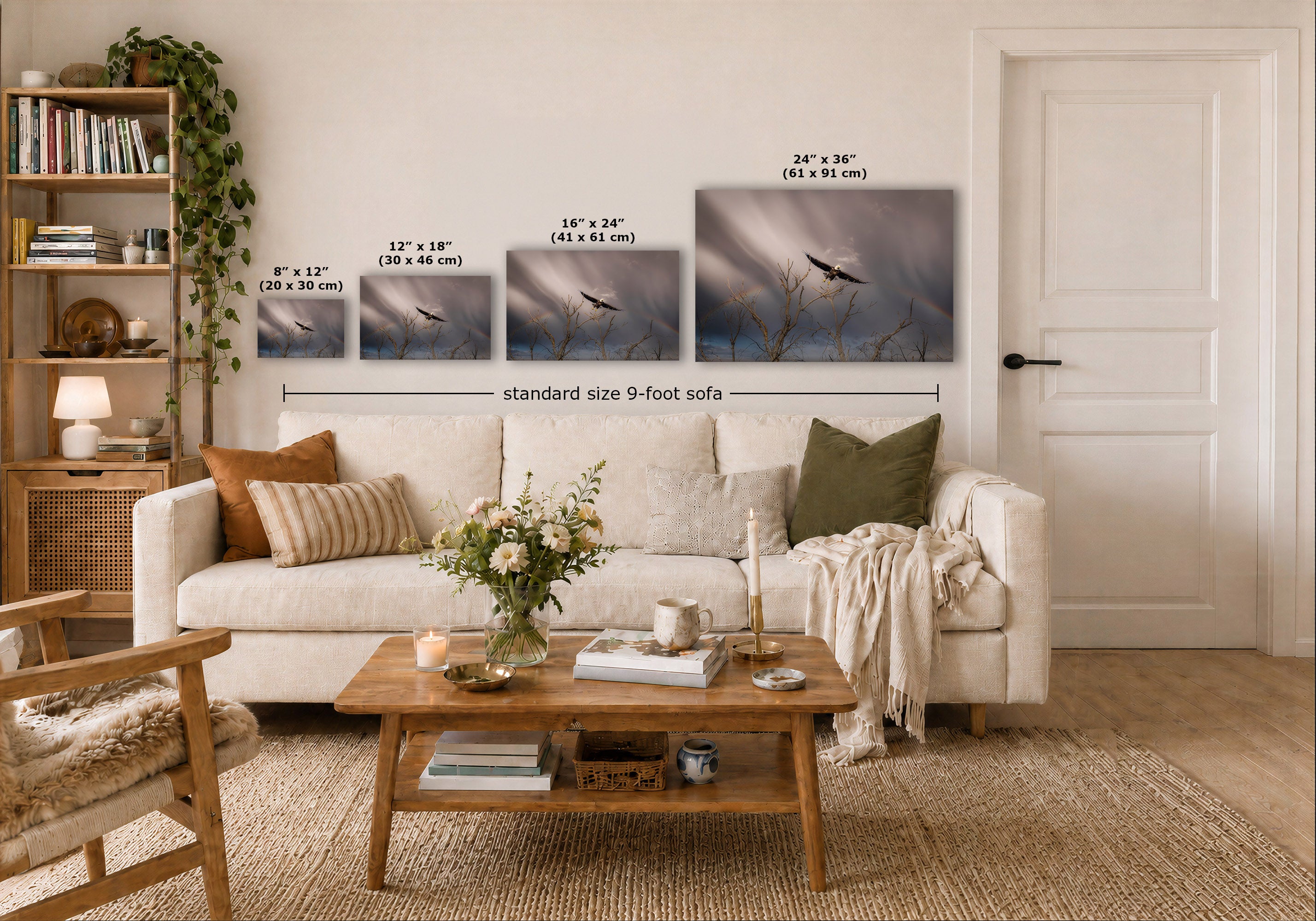 A styled living room showing four wall art prints above a white sofa, with size labels for each print and a dimension marker reading standard size 9-foot sofa. The prints depict a moody bird scene in blue-gray, gray, and muted purple tones.