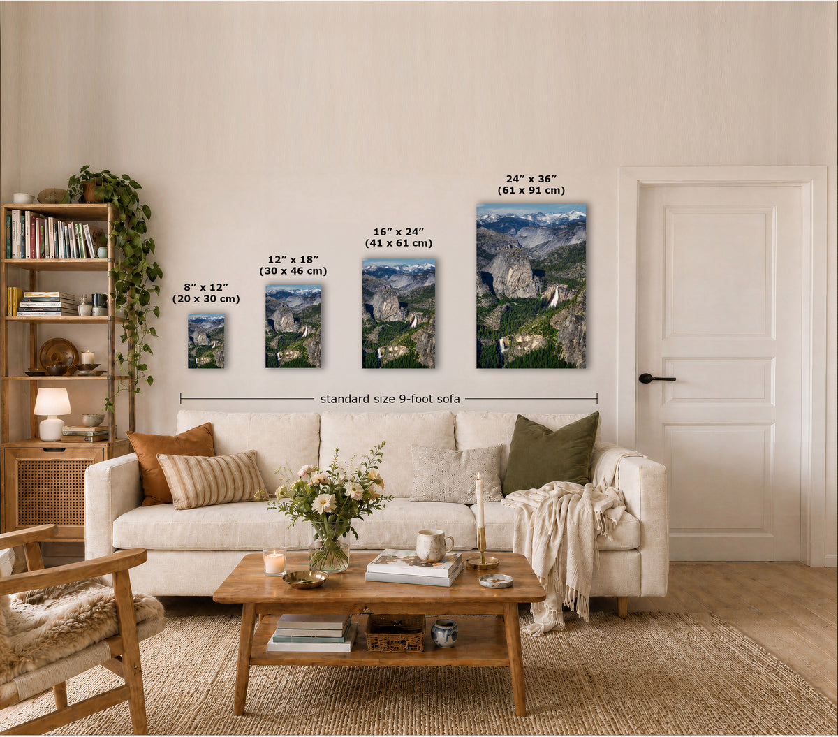 Four wall art prints showing mountain landscapes are displayed above a cream sofa in a styled living room. White text labels indicate the dimensions of each print: 8" x 12", 12" x 18", 16" x 24", and 24" x 36", with a note reading 'standard size 9-foot sofa' below the frames.
