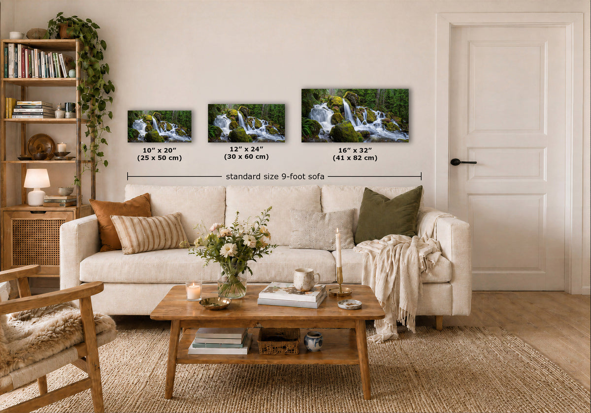 Three Oregon cascading waterfall prints showing waterfall landscapes are displayed above a white sofa in a styled living room.