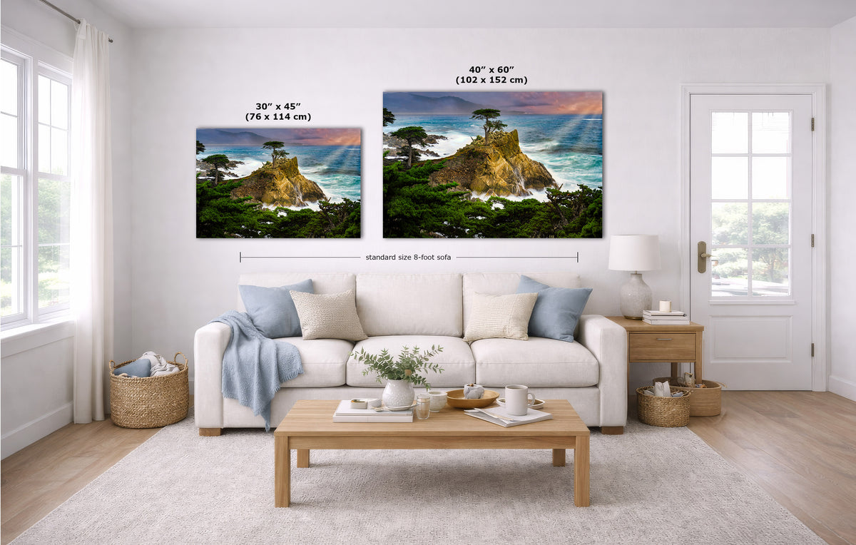 Two coastal landscape wall art prints of the Lone Cypress tree are shown hanging above a white sofa in a bright living room. The left print is labeled 30 x 45 inches, and the right print is labeled 40 x 60 inches, with a dimension line between them.