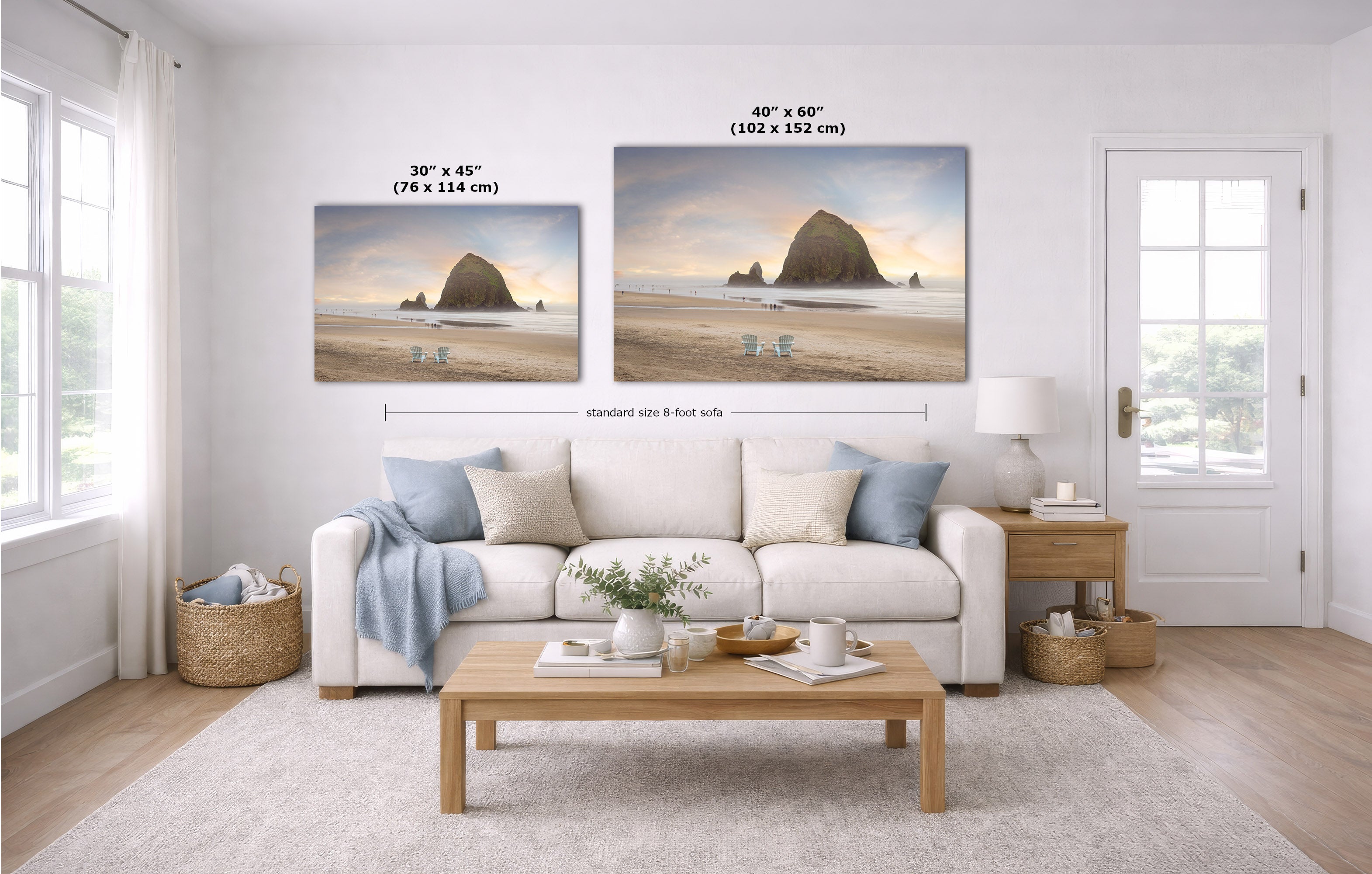 A staged living room shows two wall art prints above a white sofa. The prints depict a beach shoreline with large rock formations at sunset.