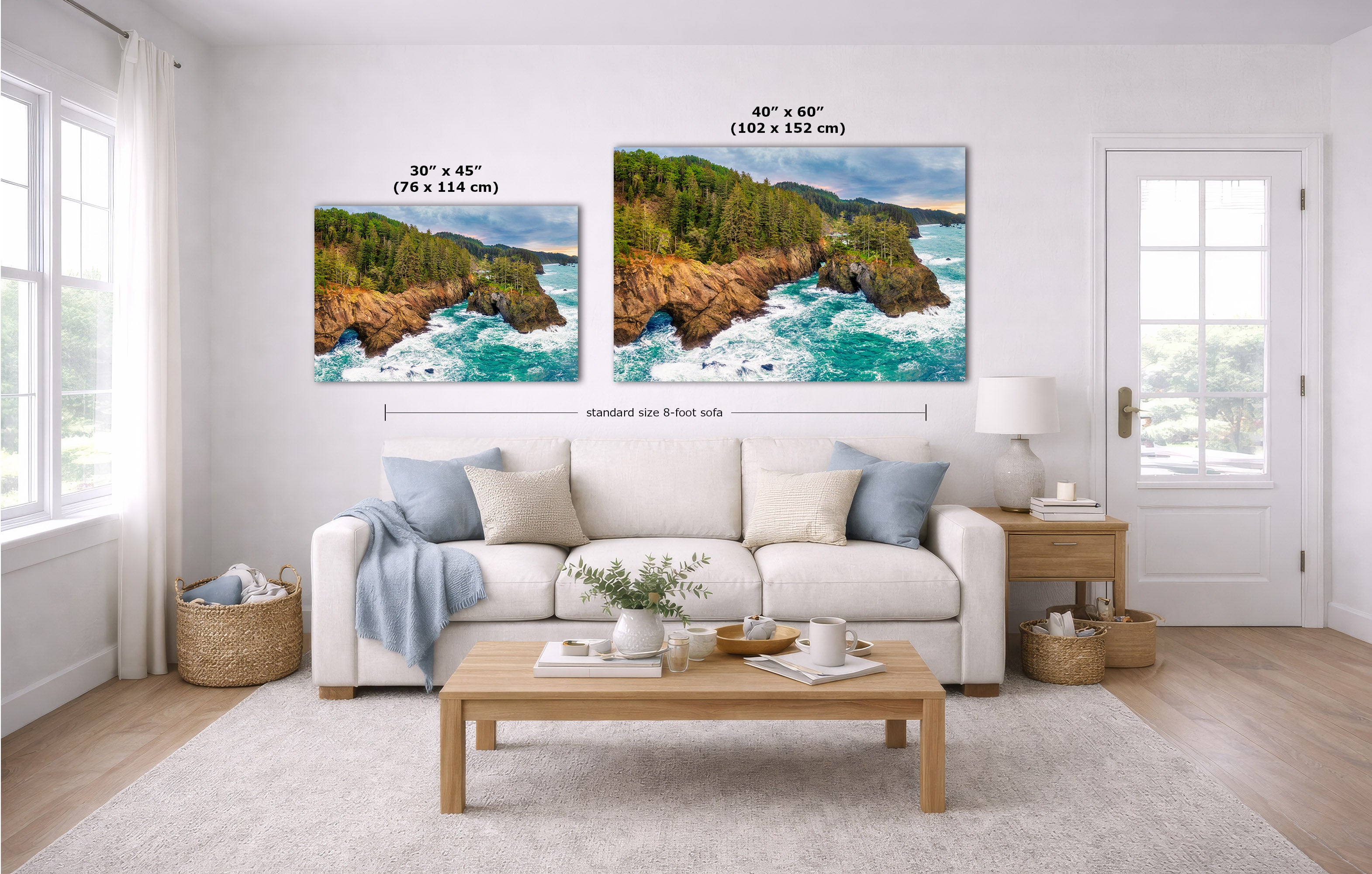 A staged living room with a white sofa, coffee table, and two coastal landscape prints on the wall. The prints show rocky cliffs and turquoise ocean water, with size labels above each print reading 30 x 45 inches and 40 x 60 inches.
