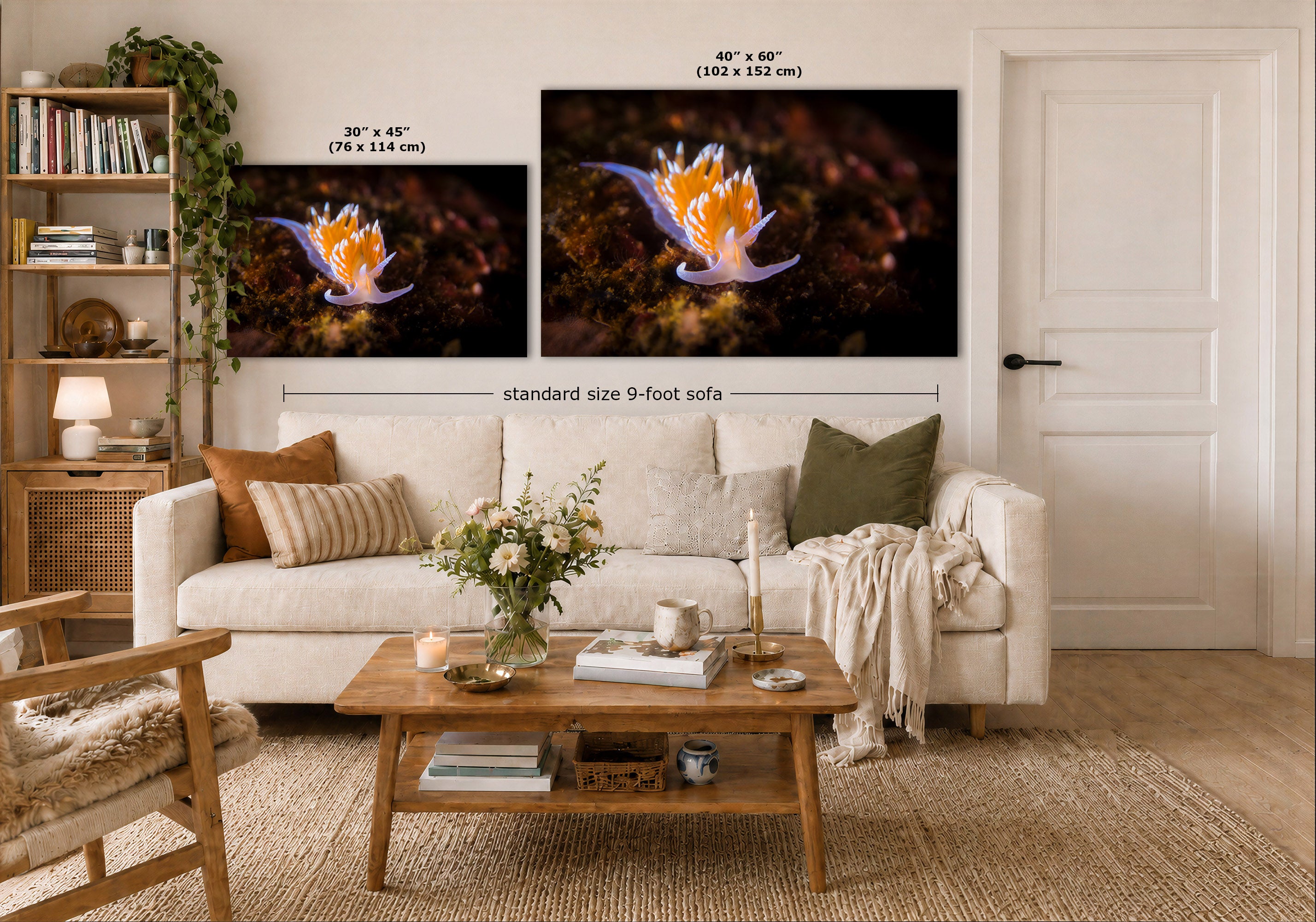 A styled living room showing two wall art prints above a white sofa. The prints depict a vivid underwater scene with a white and orange nudibranch on a dark background.