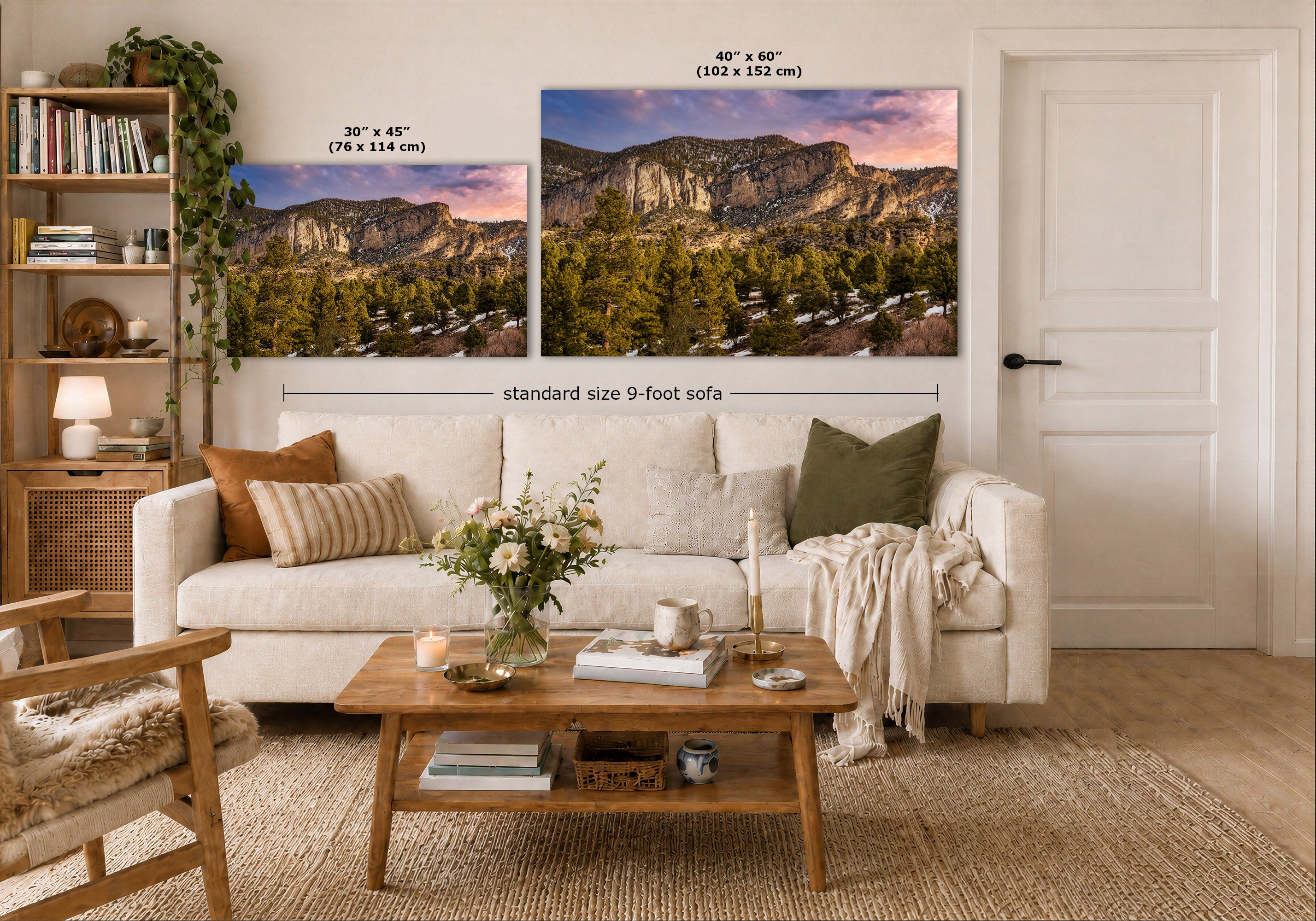 A styled living room showing two wall art prints above a white sofa. The prints depict mountain landscapes at sunset, with one smaller 30 x 45 inch print and one larger 40 x 60 inch print.