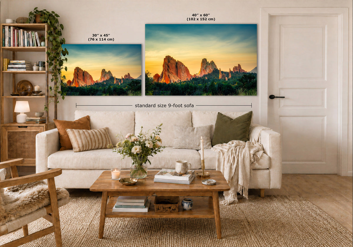 A styled living room showing two wall art prints above a white sofa. The prints depict a colorful desert rock landscape at sunset, with one smaller 30 x 45 inch print and one larger 40 x 60 inch print.