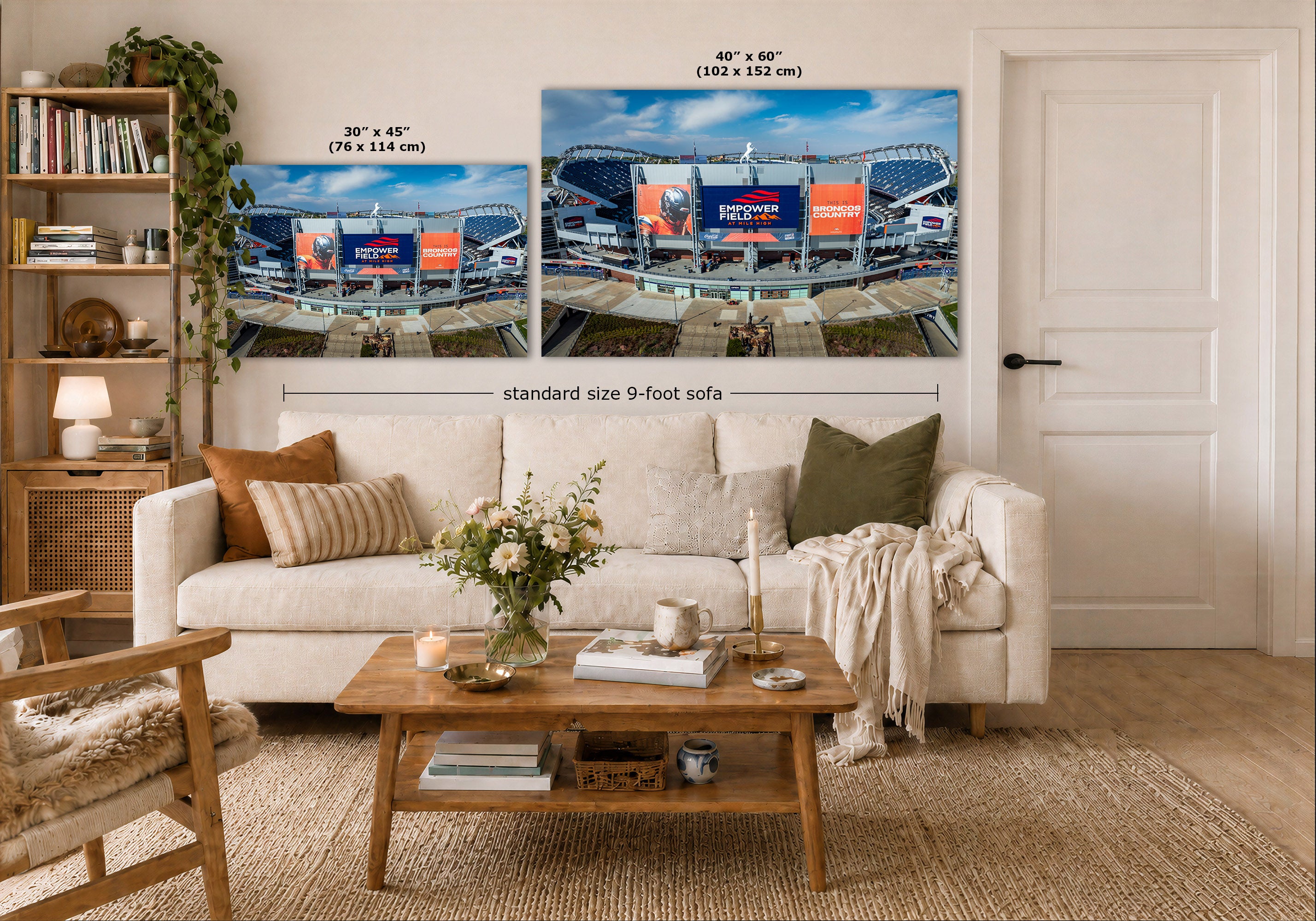A staged living room shows a Broncos Empower Field Wall Art set featuring two stadium scenes mounted above a white sofa. The image includes size callouts for the prints: one 30 x 45 in (76 x 114 cm) and one 40 x 60 in (102 x 152 cm), with a note reading standard size 9-foot sofa.