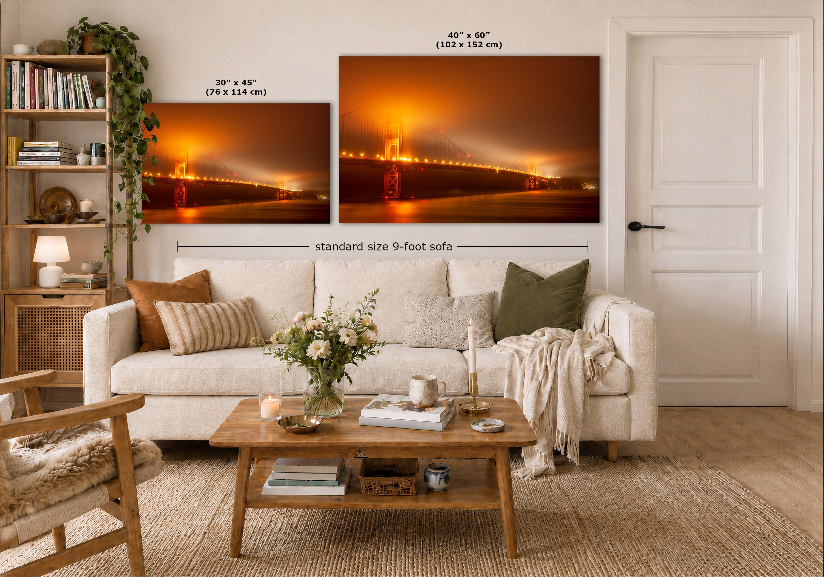 A styled living room showing two wall art prints above a cream-colored sofa. The prints depicts a view of San Francisco's Golden Gate Bridge glowing in orange fog at night.