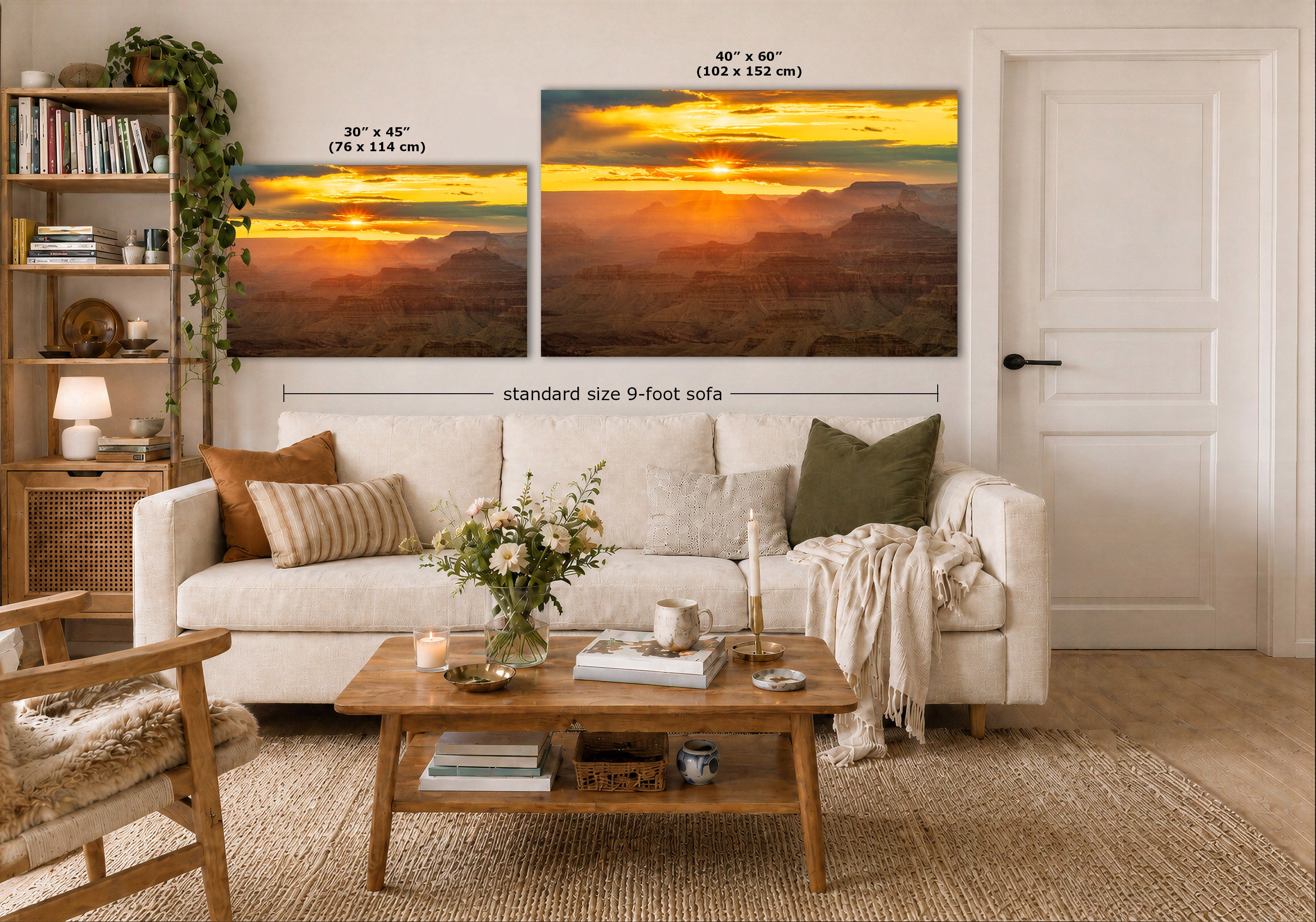 A staged living room shows two landscape wall art prints above a white sofa. The prints depict a warm sunset over layered mountains or canyons in yellow, orange, and brown tones.