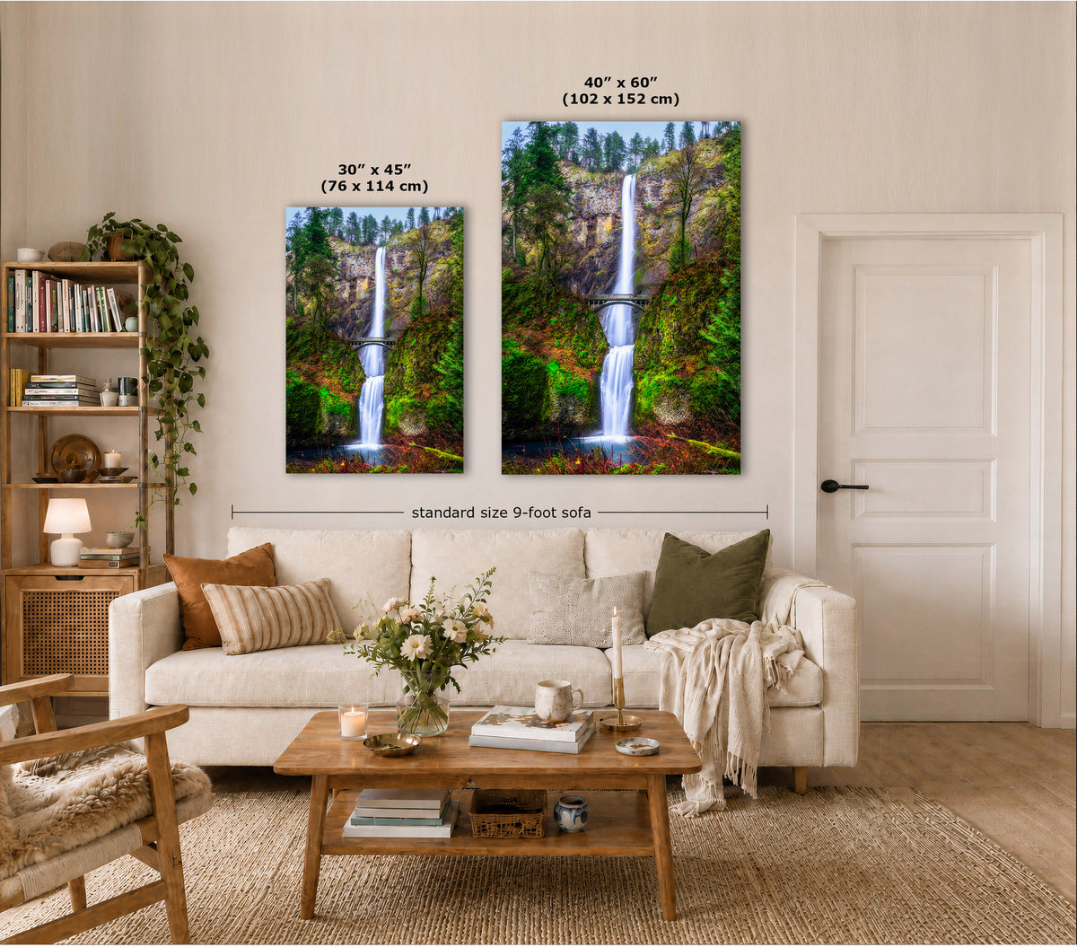 Two vertical canvas prints showing waterfall landscapes in lush green scenery, displayed on a beige wall above a white sofa in a styled living room. Text overlays indicate the sizes: 30" x 45" (76 x 114 cm) for the smaller print, 40" x 60" (102 x 152 cm) for the larger print, and a 9-foot sofa width below.