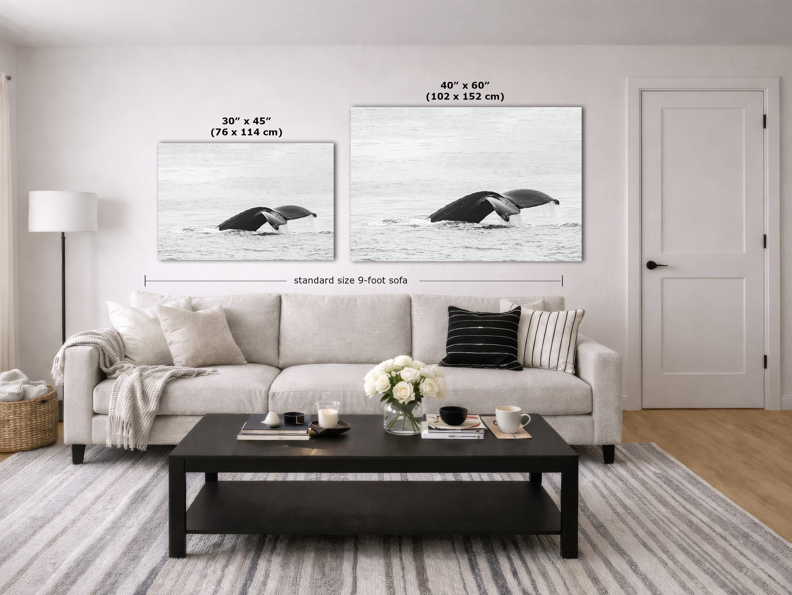 A styled living room showing two whale wall art prints above a sofa, with size labels overlaid: a smaller 30 x 45 inch print and a larger 40 x 60 inch print. The room includes a light sofa, a black coffee table, a rug, a lamp, and a door.