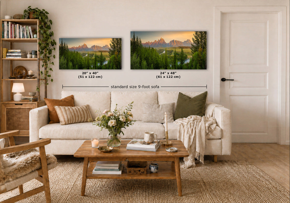 Two framed mountain landscape prints hang above a white sofa in a styled living room. The left print is labeled 20 x 40 inches (51 x 122 cm) and the right print 24 x 40 inches (61 x 122 cm), with text reading 'standard size 9-foot sofa.