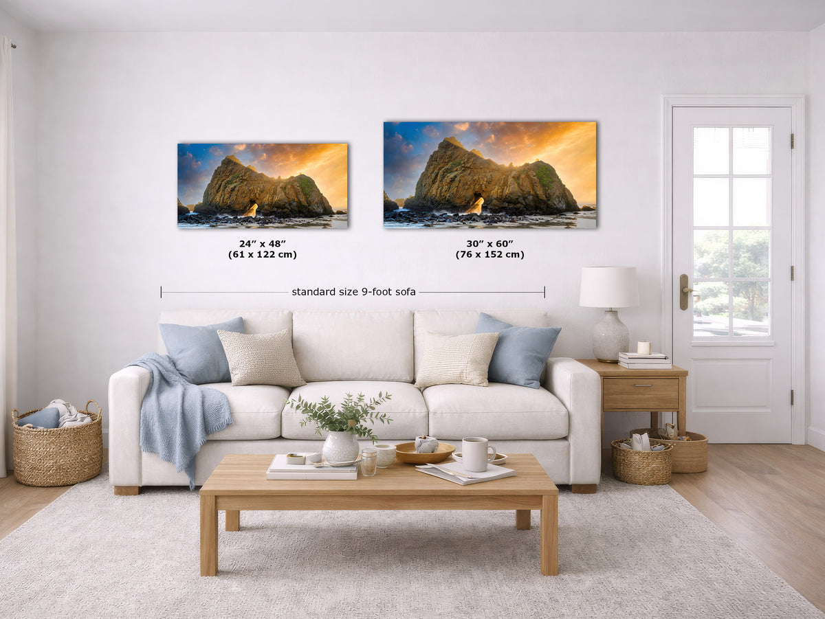 Two framed wall art prints showing rocky cliffs at sunset are displayed above a white sofa in a bright living room. Black measurement lines and text indicate the prints measure 24 x 48 inches and 30 x 60 inches, with 'standard size 9-foot sofa' written below.