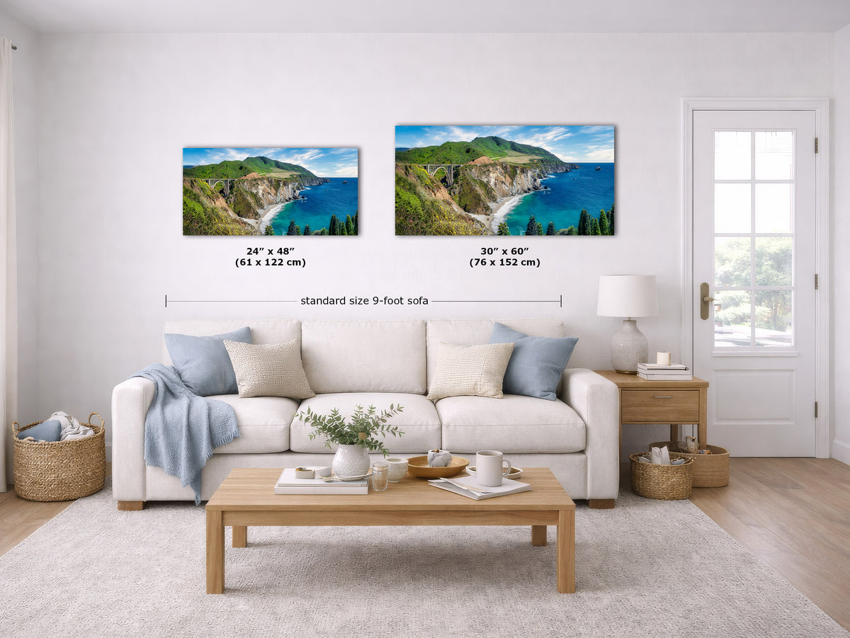 A staged living room shows two framed coastal landscape prints above a white sofa. The left print is labeled 24 x 48 inches and the right print labeled 30 x 60 inches, with a note reading standard size 9-foot sofa.
