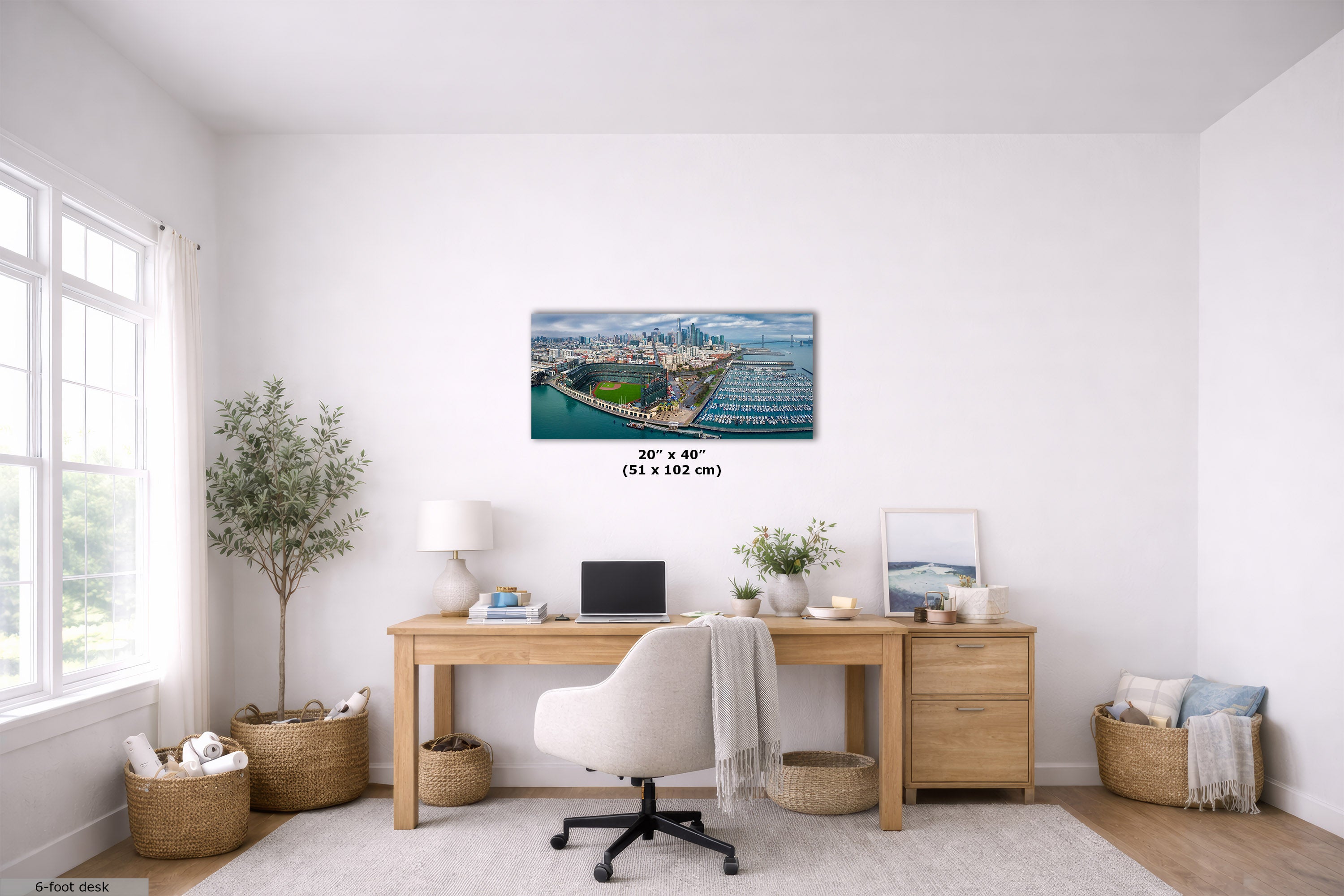A wall art print showing an aerial view of San Francisco, California, displayed in a bright, modern home office setting above a wooden desk. The print features a blue and green coastal landscape.