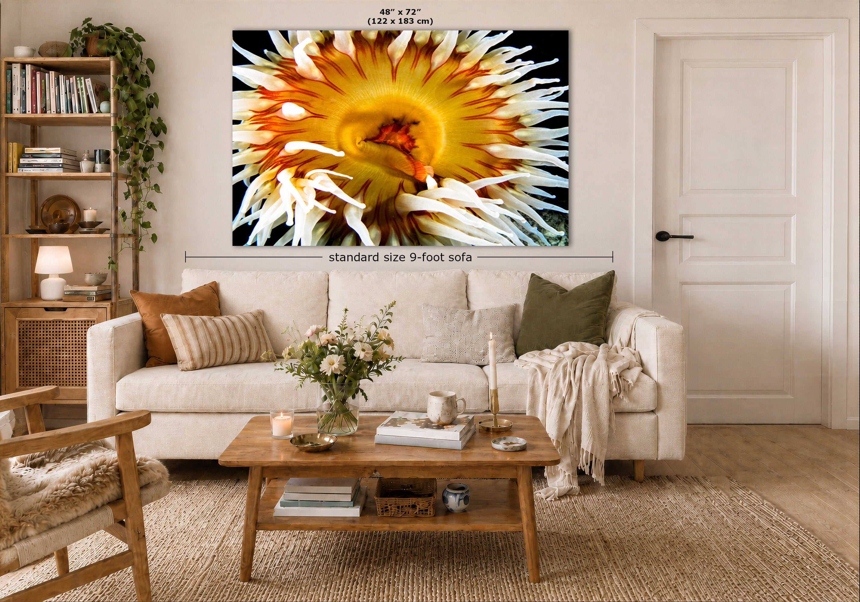 A large wall art print showing a close-up anemone hangs above a white sofa in a styled living room. The image includes dimension labels indicating the print is 48 x 72 inches and the sofa is standard size 9-foot.