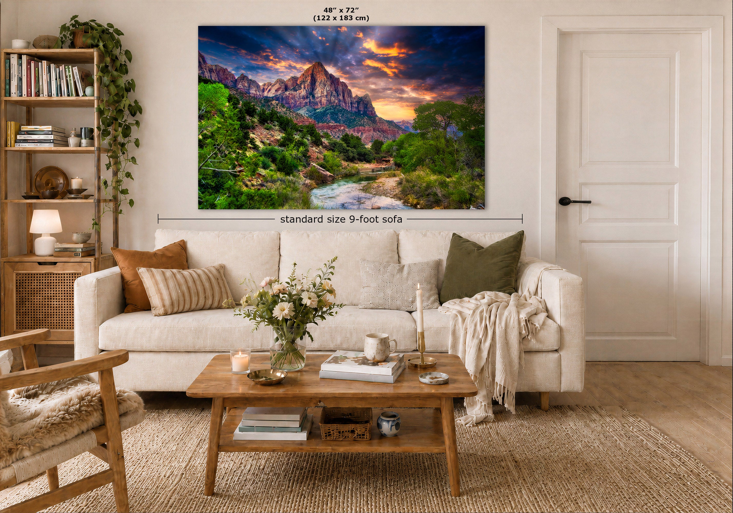 A large wall art print showing a colorful mountain landscape with a river and dramatic sunset, displayed above a white sofa in a styled living room. Measurement text indicates the print is 48 x 72 inches, and a dimension line notes standard size 9-foot sofa placement.