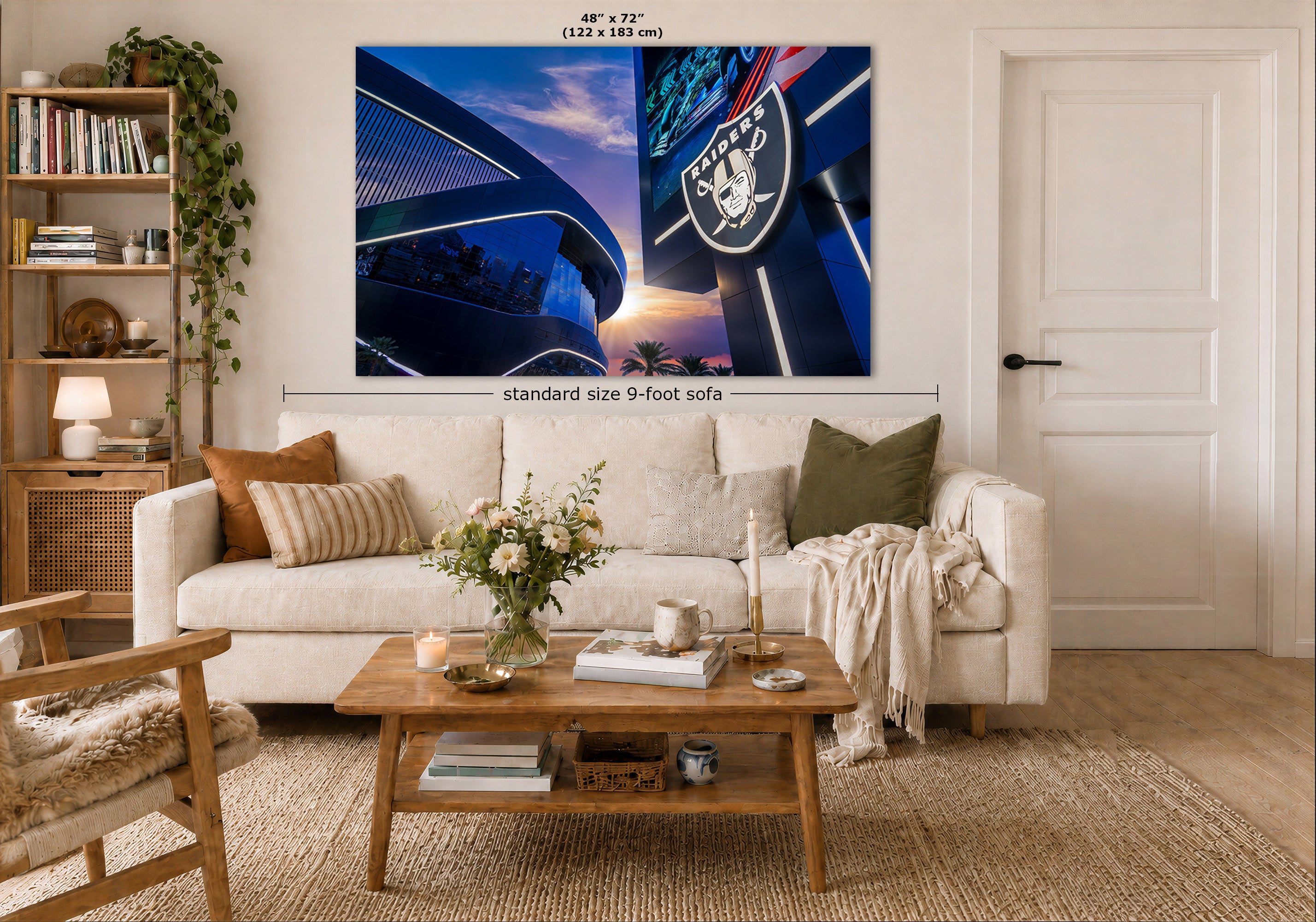 A large wall art print showing a blue-toned stadium scene with the Raiders logo is displayed above a white sofa in a styled living room. Measurement labels indicate 48 x 72 inches and standard size 9-foot sofa context.