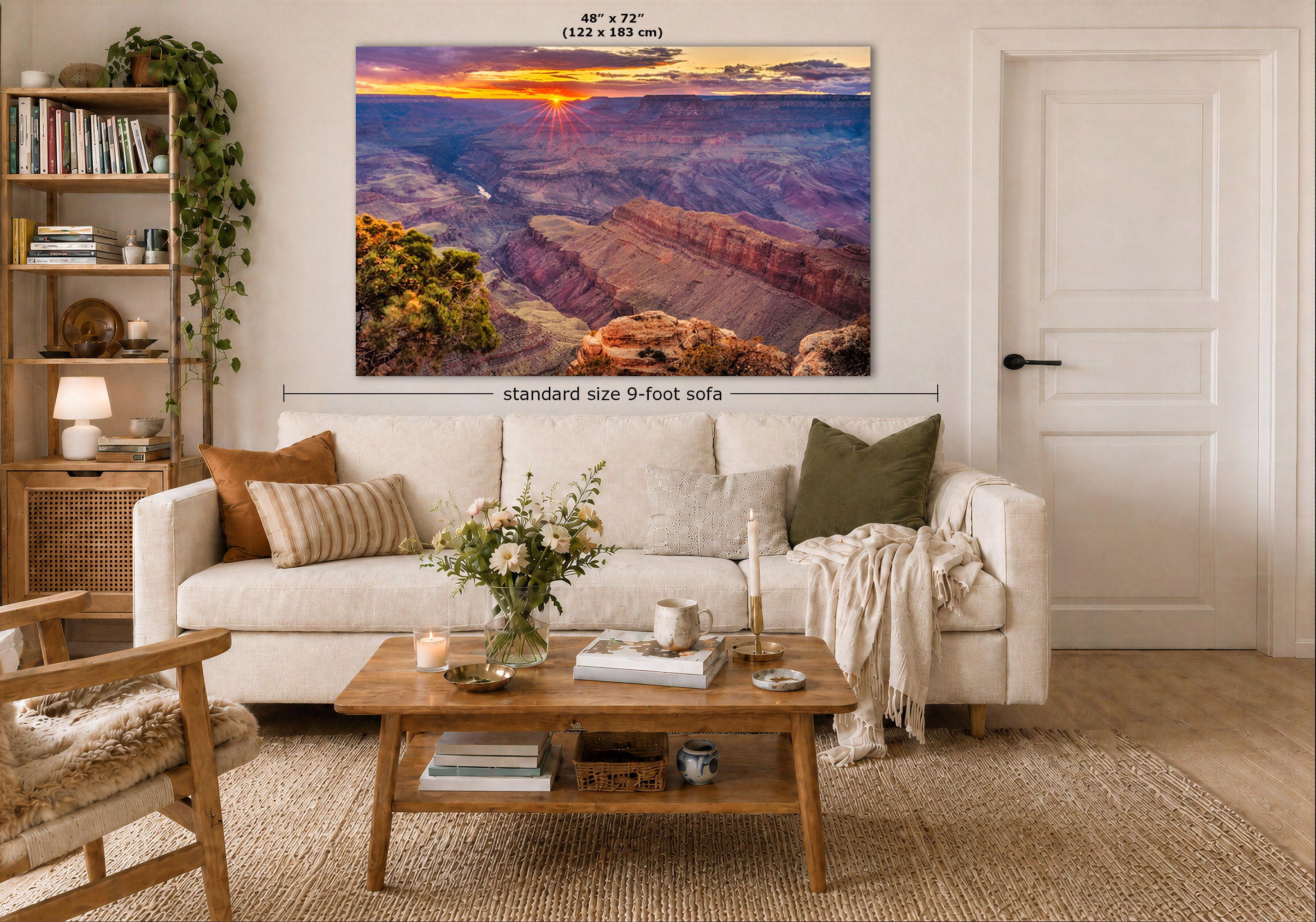 A large rectangular wall art print showing a canyon sunset scene, displayed above a white sofa in a styled living room. White text above the print reads 48" x 72" (122 x 183 cm), and a dimension line indicates standard size 9-foot sofa.
