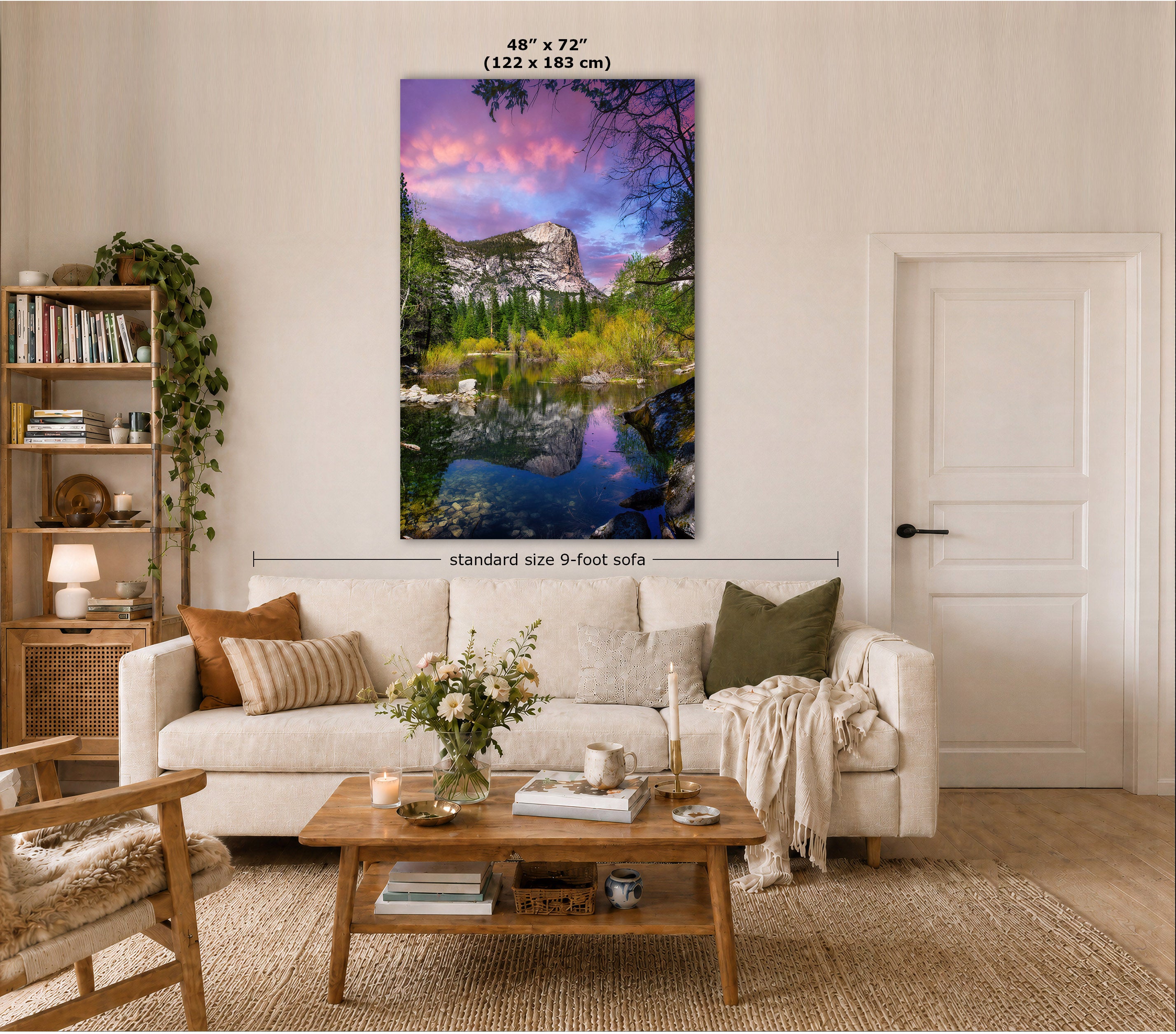 A vertical canvas wall art print showing a colorful mountain lake landscape with purple sky reflections, displayed above a white sofa in a styled living room. Text at the top indicates 48" x 72" (122 x 183 cm), and a dimension line notes standard size 9-foot sofa.