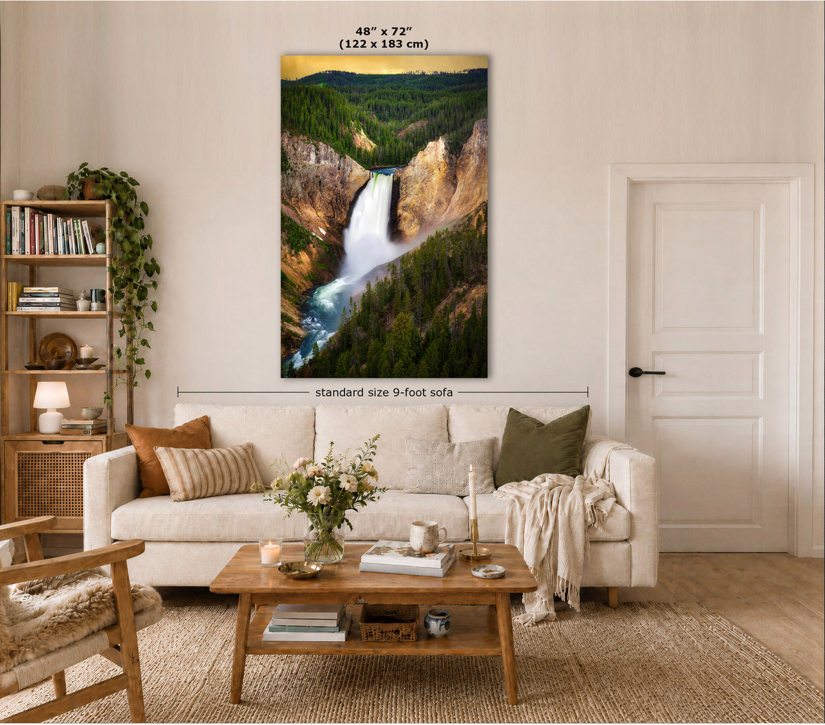 A large vertical wall art print showing a scenic waterfall and forest canyon, displayed above a white sofa in a styled living room. Text on the image indicates the print size as 48" x 72" (122 x 183 cm) and notes standard size 9-foot sofa context.