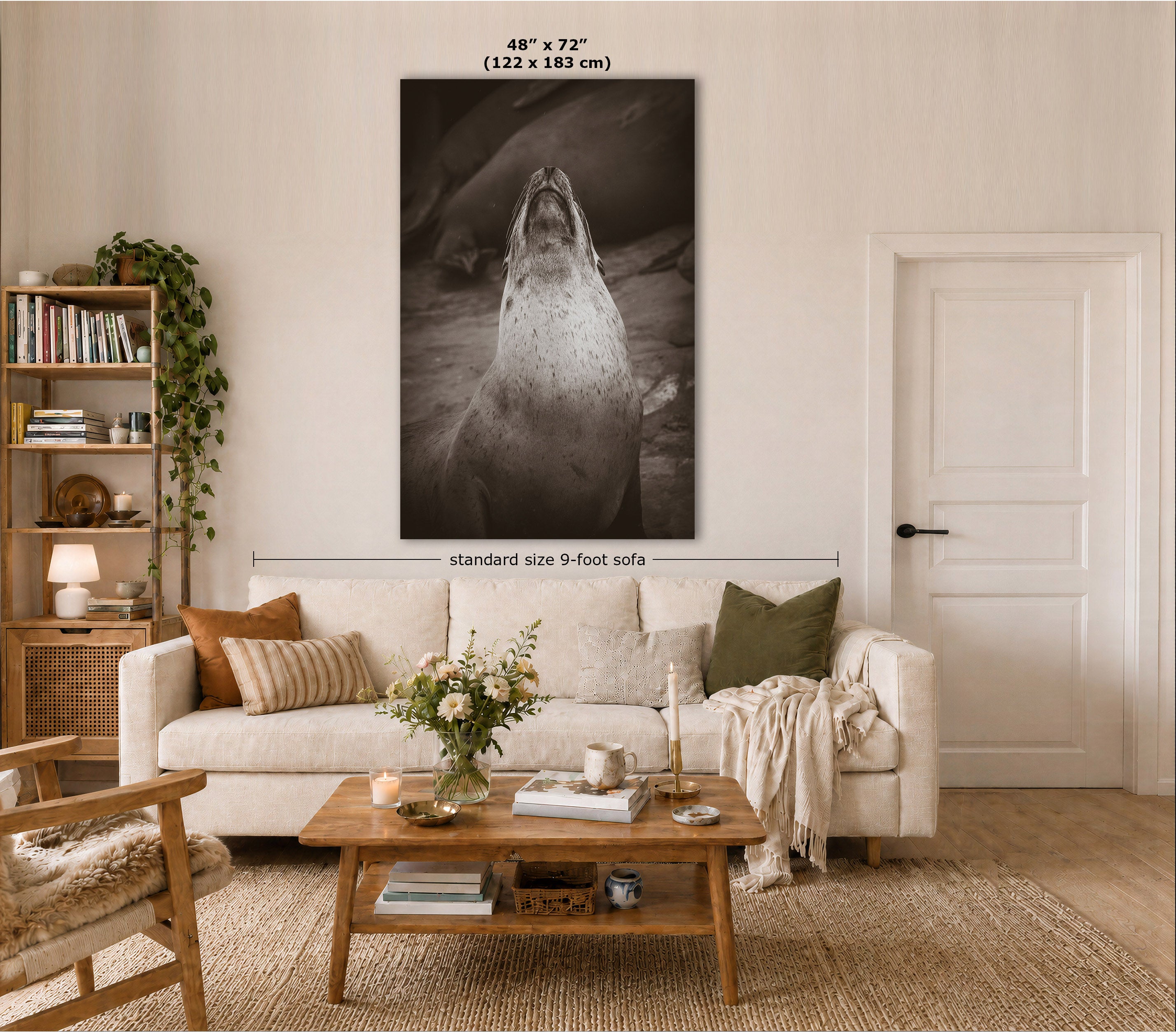 A large vertical black-and-white wall art print showing a seal or sea lion, displayed above a cream sofa in a styled living room. Text at the top reads 48" x 72" (122 x 183 cm), and a horizontal measurement line indicates standard size 9-foot sofa scale.