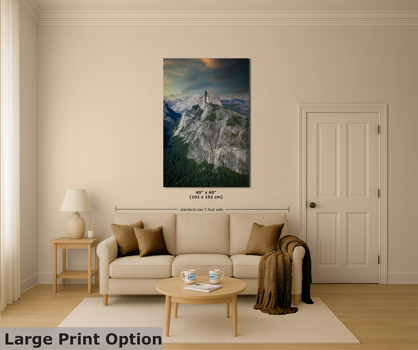 A large wall art print depicting a mountain landscape, Half Dome in Yosemite, is shown hanging above a beige sofa in a styled living room. The print is labeled with dimensions (80 x 60 inches) and includes a text overlay at the bottom that reads 'Large Print Option'.