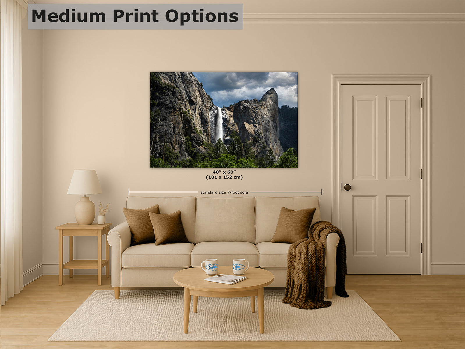 A framed wall art decor print showing Yosemite's Bridalveil waterfall between rocky cliffs under a cloudy sky, displayed above a beige sofa in a styled living room. The image includes the text 'Medium Print Options' and size information overlaid on the scene.